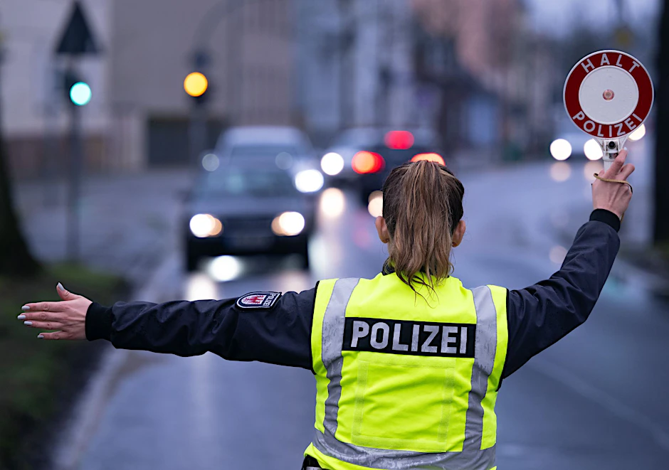 Eine Polizistin winkt ein Auto von der Straße auf den Kontrollplatz. Wer in Deutschland den Führerschein entzogen bekommt, soll in der ganzen EU nicht mehr fahren dürfen.