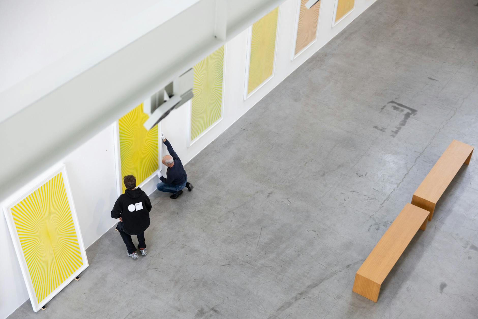 Mitarbeiter bringen Bilder des Künstlers Mark Grotjahn an einer Wand der Galerie Max Hetzler an.