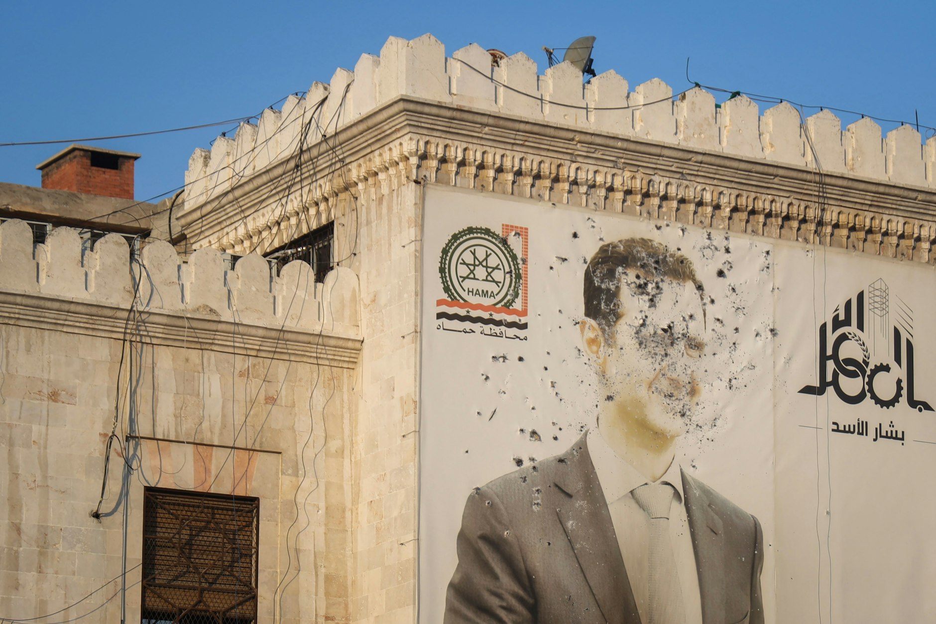 Zerschossenes Propaganda-Poster mit dem Bild von Diktator Baschar al-Assad in der am Donnerstag befreiten Stadt Hama. Neue Nachrichten über weitere Eroberungen der Regimegegner kommen stündlich. Assad könnte noch dieses Jahr stürzen.