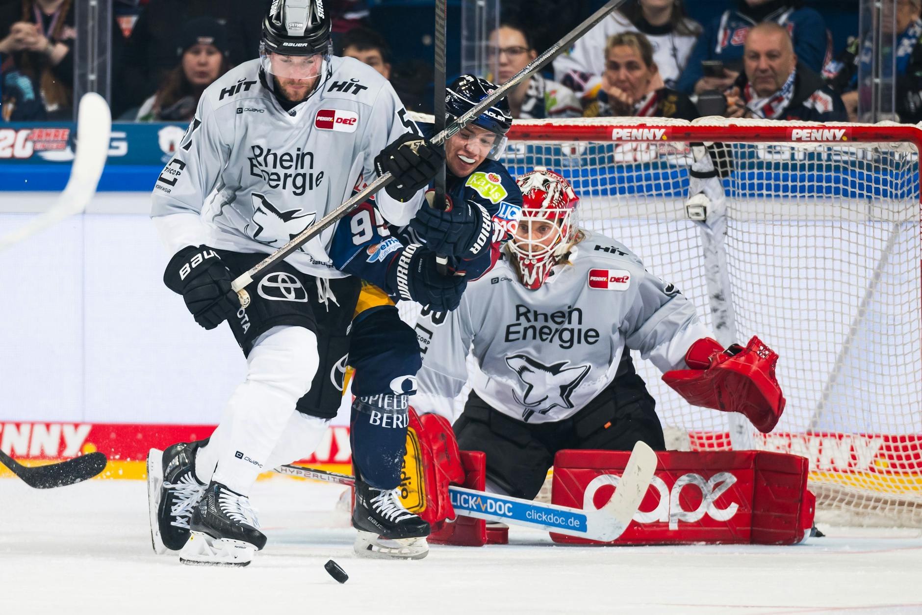 Eisbär Freddy Tiffels (M.) hat's gegen Kölns Brady Austin nicht leicht, gleich dahinter lauert Haie-Goalie Mirko Pantkowski.