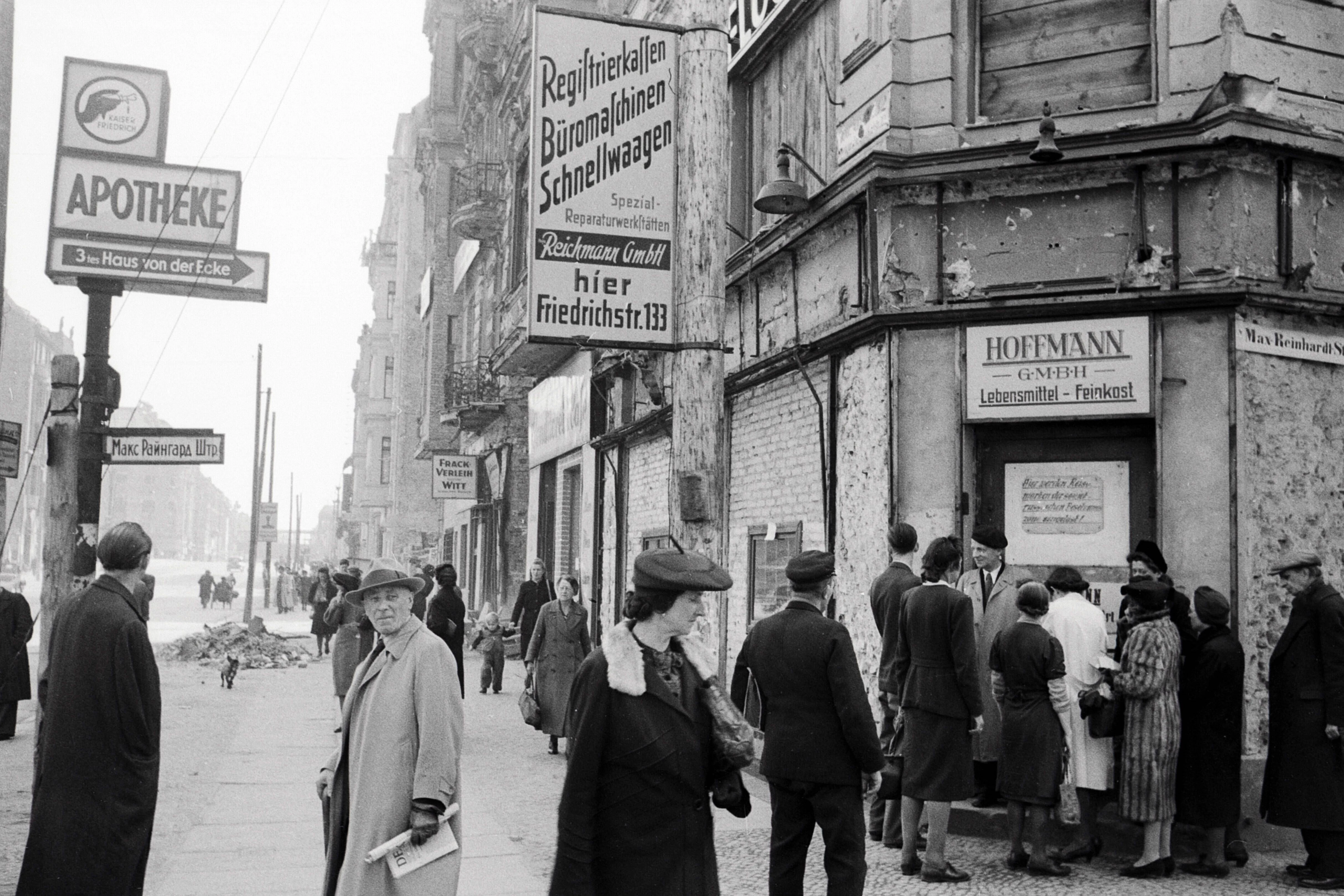 Menschen versammeln sich im Jahr 1947 in der Friedrichstraße vor einem Lebensmittelladen.