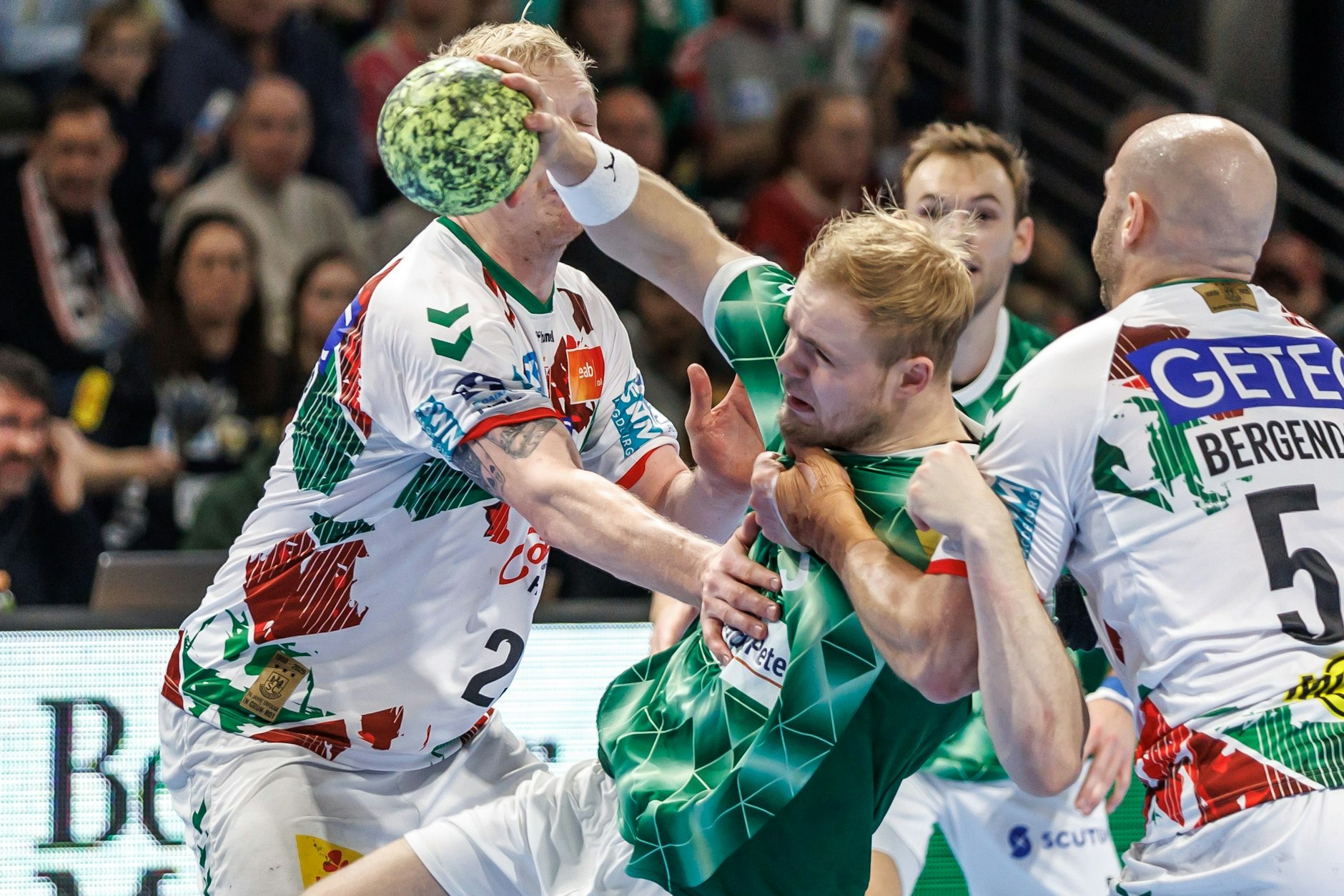 Berlins Matthes Langhoff (M.) kämpft sich durch die Abwehr von Magnus Saugstrup Jensen (l). und Oscar Bergendahl von SC Magdeburg.