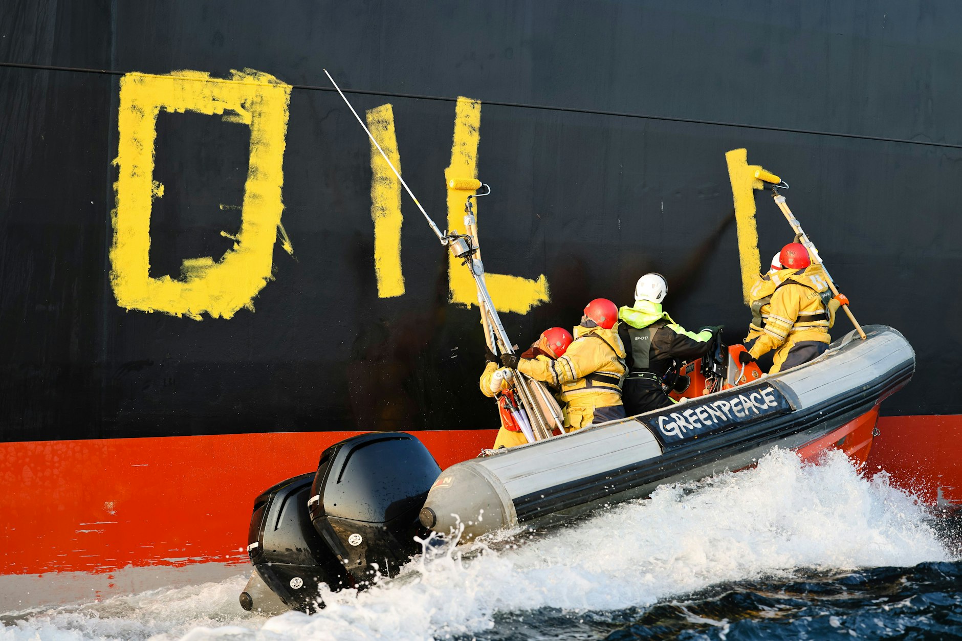 Fehmarn: Aktivisten der Umweltorganisation Greenpeace malen den Schriftzug „Oil fuels war“ auf den Rumpf eines Schiffes, das russisches Öl auf der Ostsee transportiert.