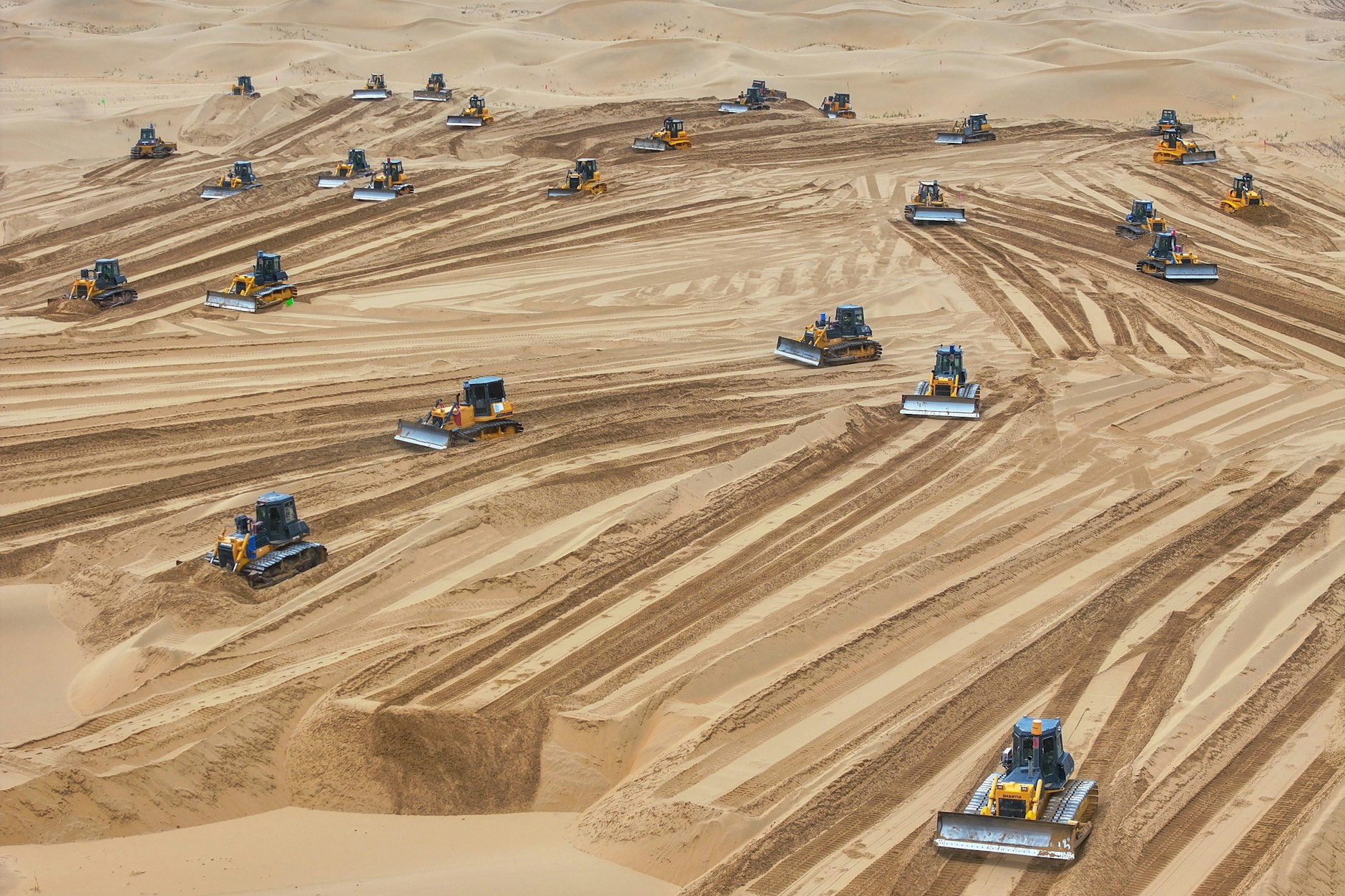 Ein 2024 aufgenommenes Drohnenfoto zeigt Maschinen auf einer Baustelle der neuen Energiebasis Shuofang in Hangjin-Banner in der nordchinesischen Autonomen Region Innere Mongolei.