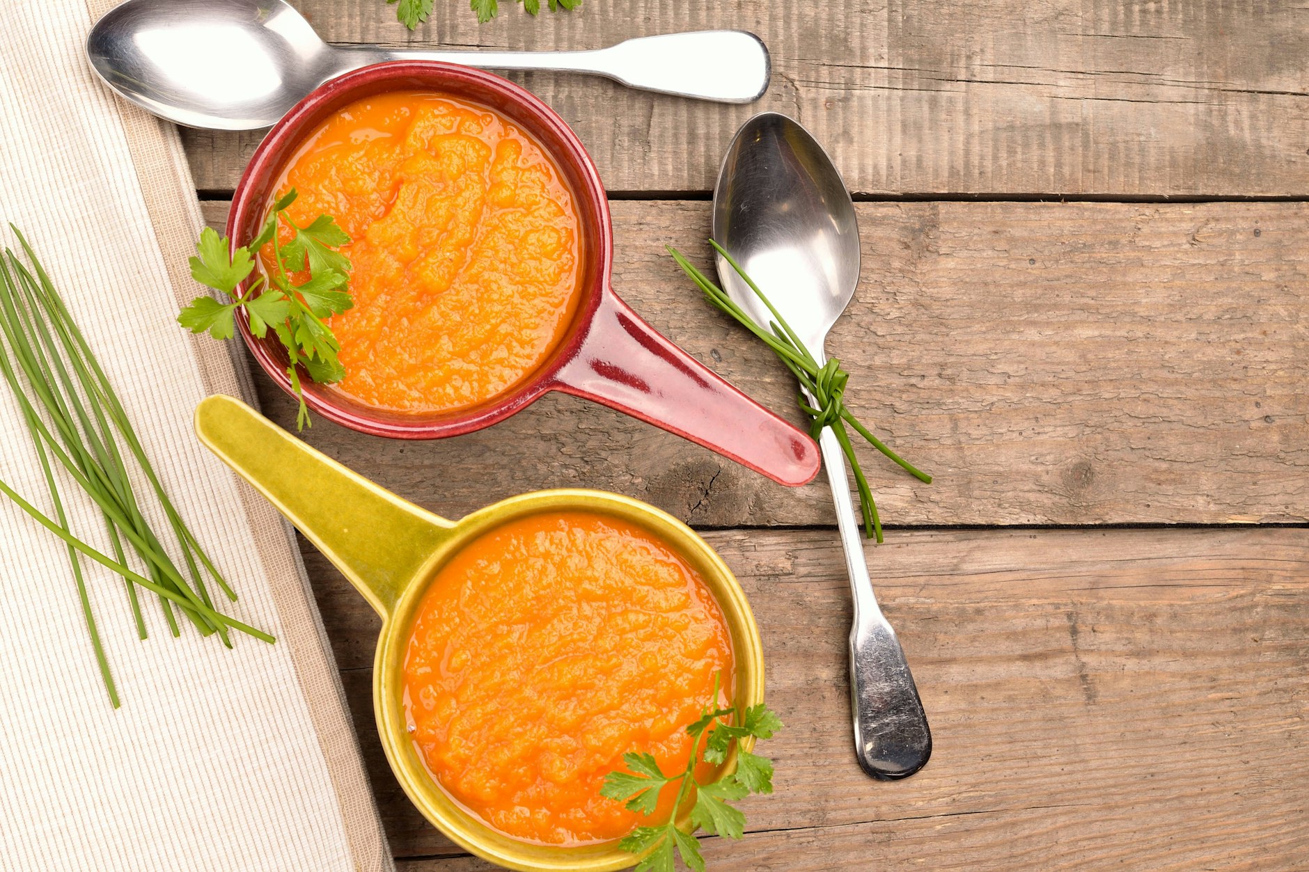 Eine Schüssel cremige Möhrensuppe, garniert mit frischen Kräutern - es fehlt nur noch ein knuspriges Baguette.