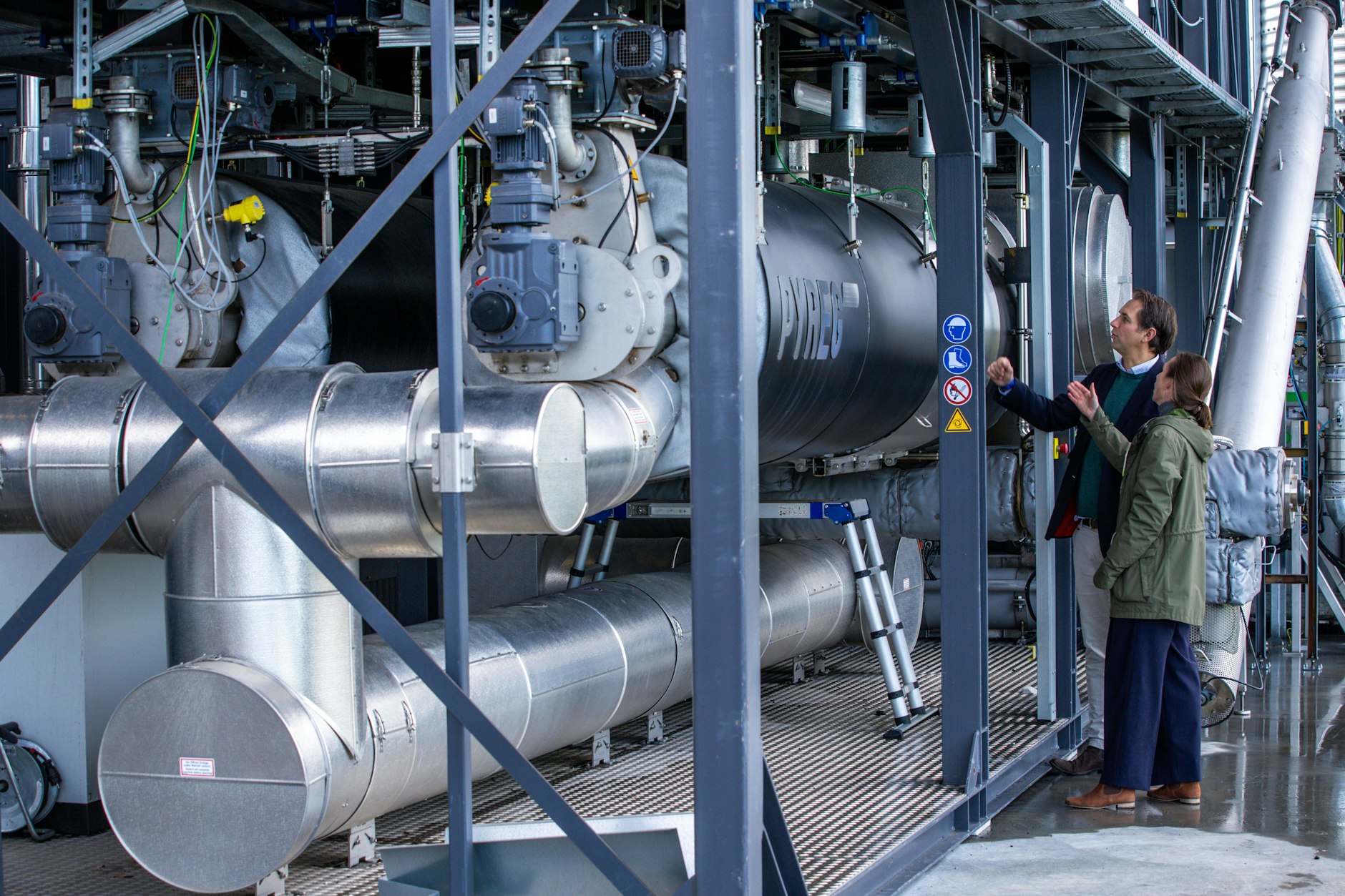 Caspar von Ziegner (l) und Senna von Level von der Firma Novocarbo stehen in der Anlage «Carbon Removal Park Baltic Sea» zur Umwandlung von Biomasse in Pflanzenkohle. Mit dem Prozess wird dauerhafte Kohlendioxid gebunden.