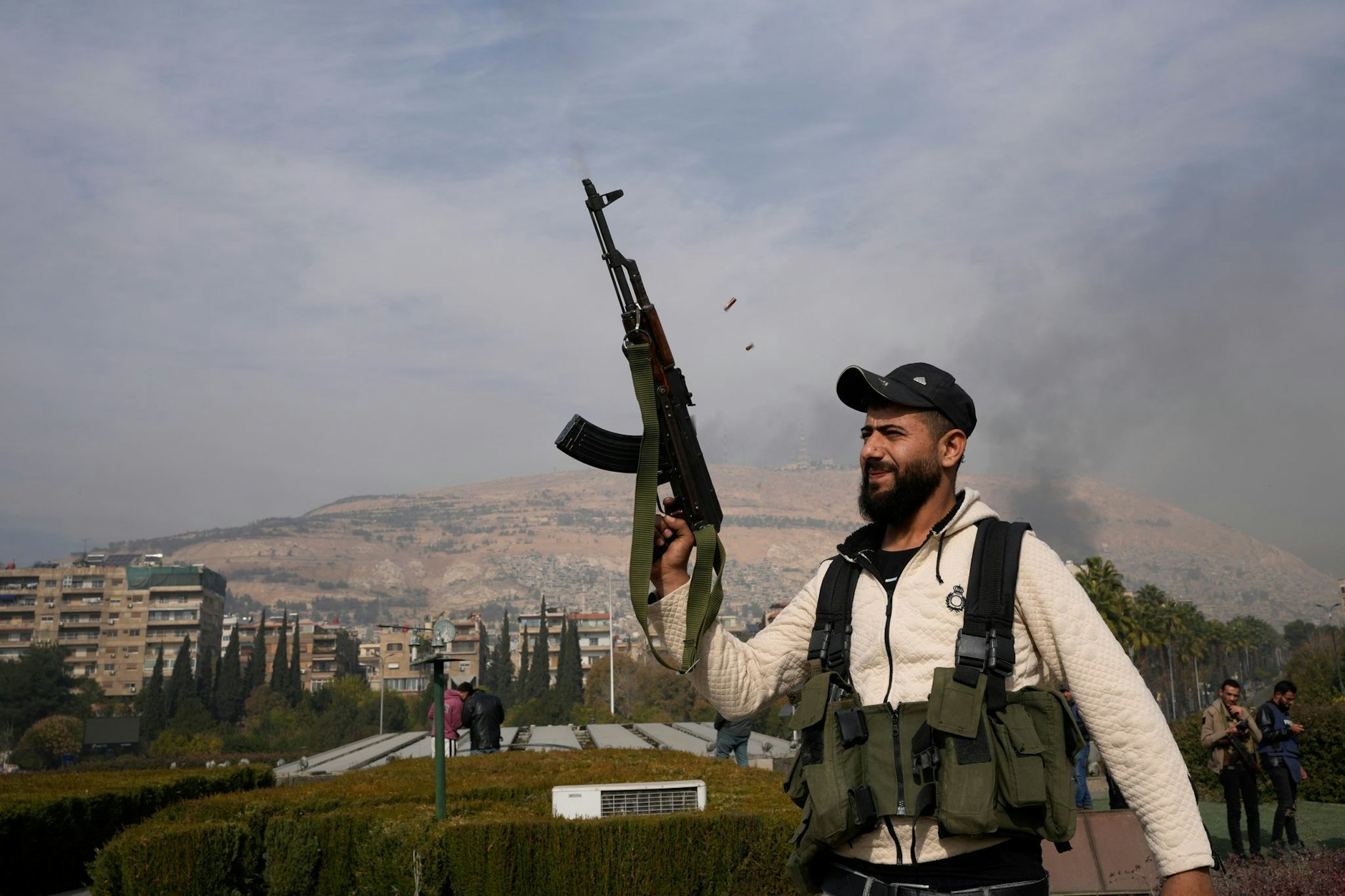 Ein Oppositionskämpfer feuert nach dem Sturz von Baschar al-Assad mit seiner AK-47 in die Luft.