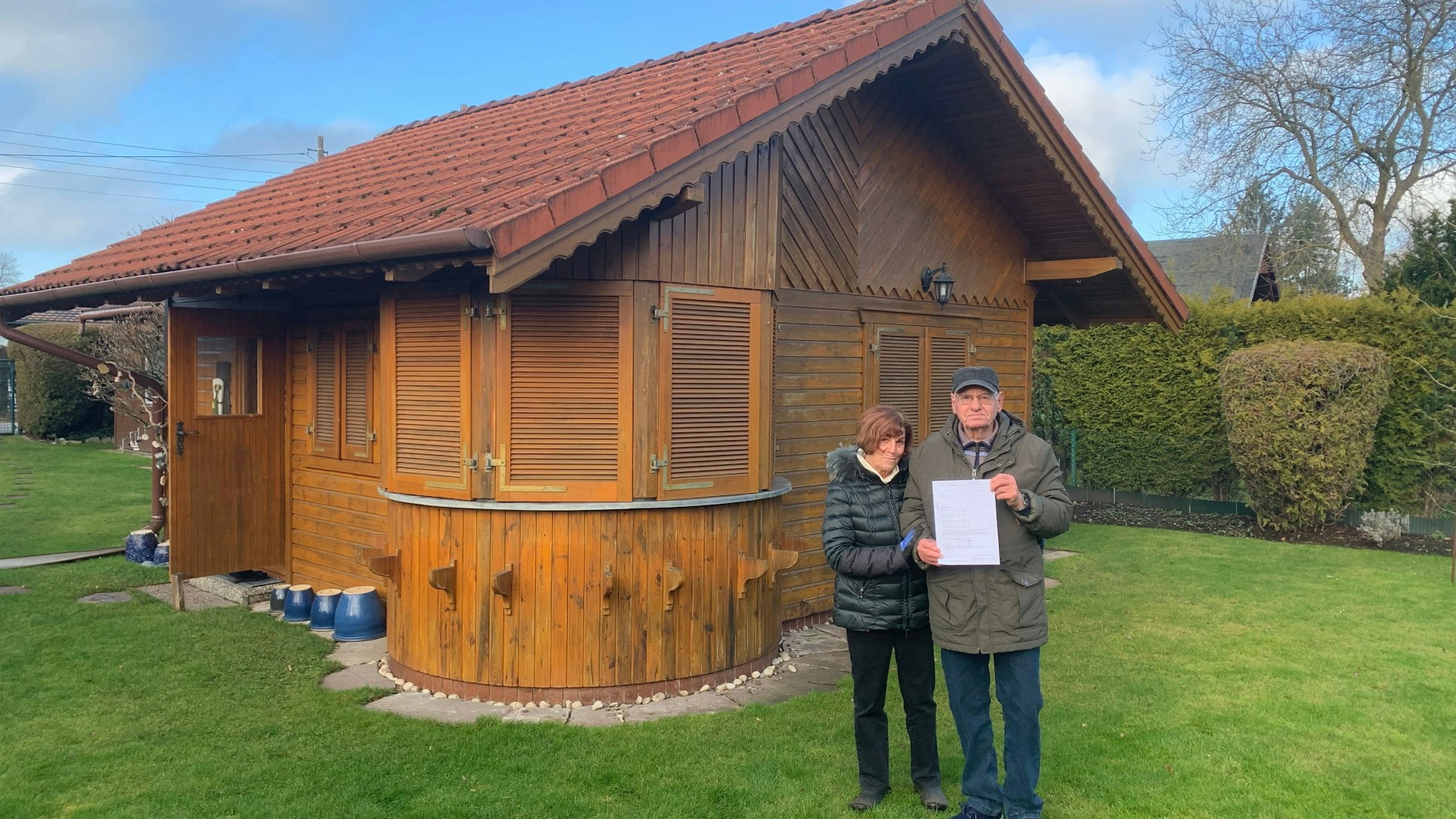 Vor ihrem Wochenendhäuschen: Die Rentner Kristina (81) und Achim Girke (83) mit dem Grundsteuerbescheid. Sie müssen künftig 956 Euro statt 80 Euro im Jahr zahlen.  