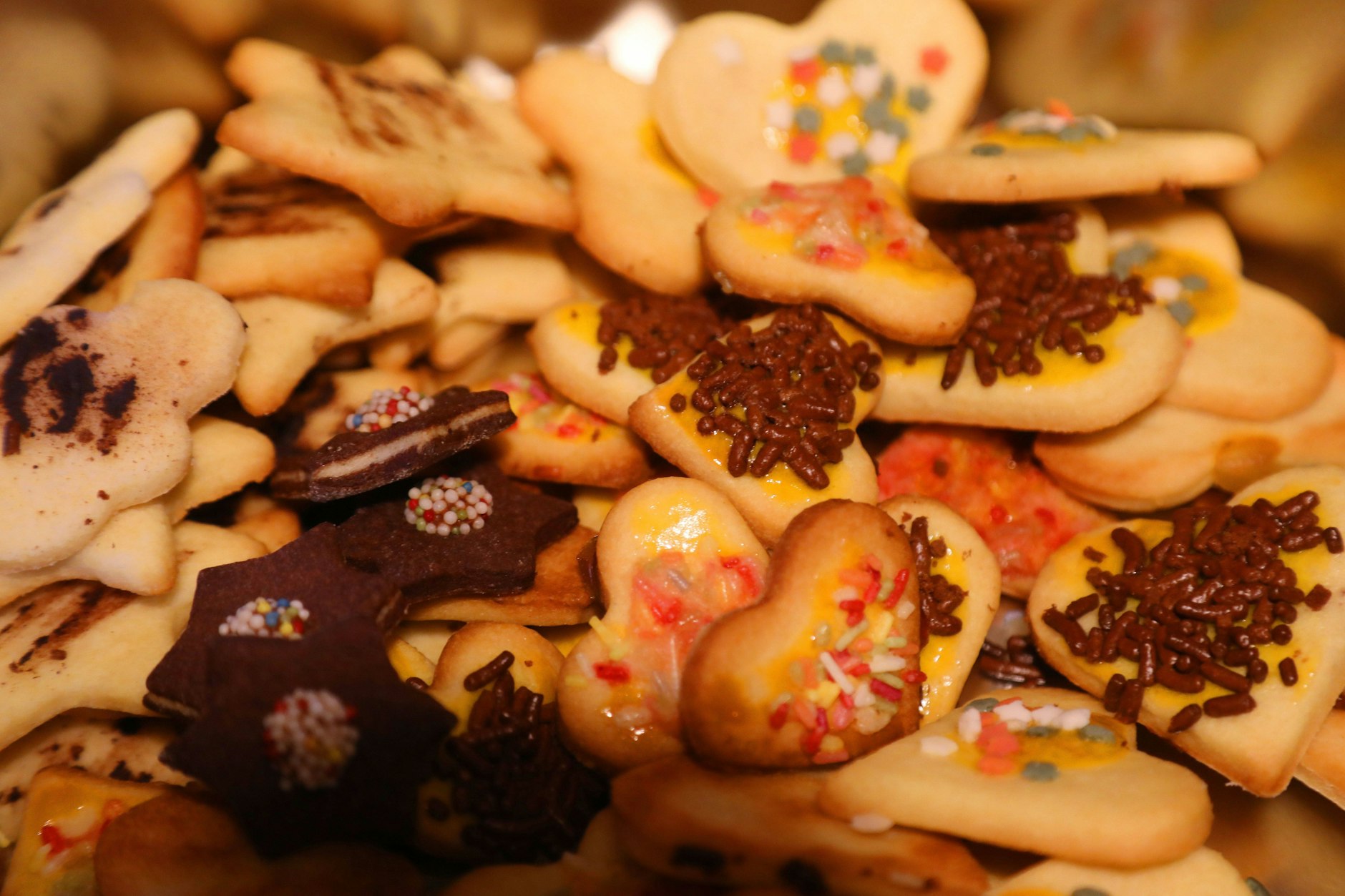 Die Plätzchen können mit dunkler Schokolade, Zuckerguss und bunten Streuseln verziert werden.