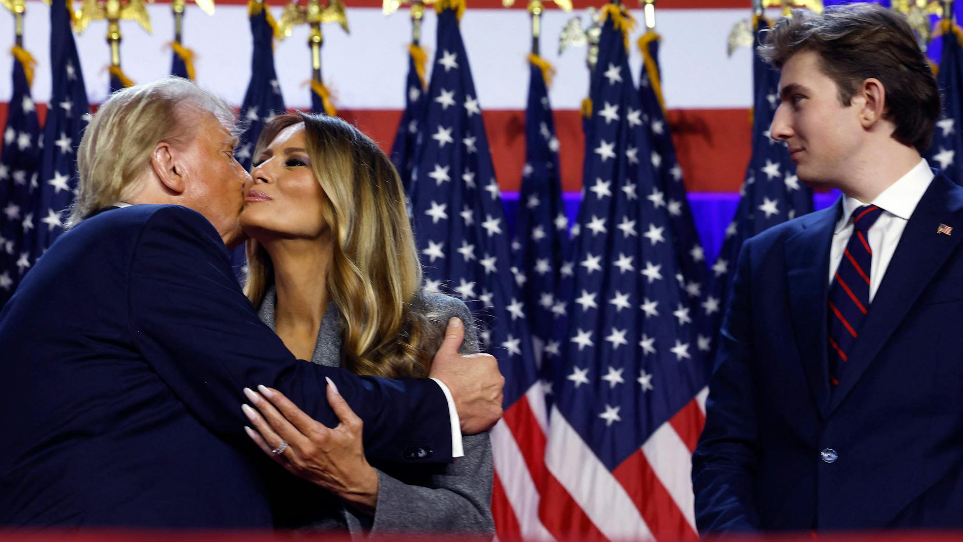 Show oder echt? Donald Trump und Gattin Melania küssen sich zum Wahlsieg. Was denkt Sohn Barron (rechts) wohl in dem Augenblick?