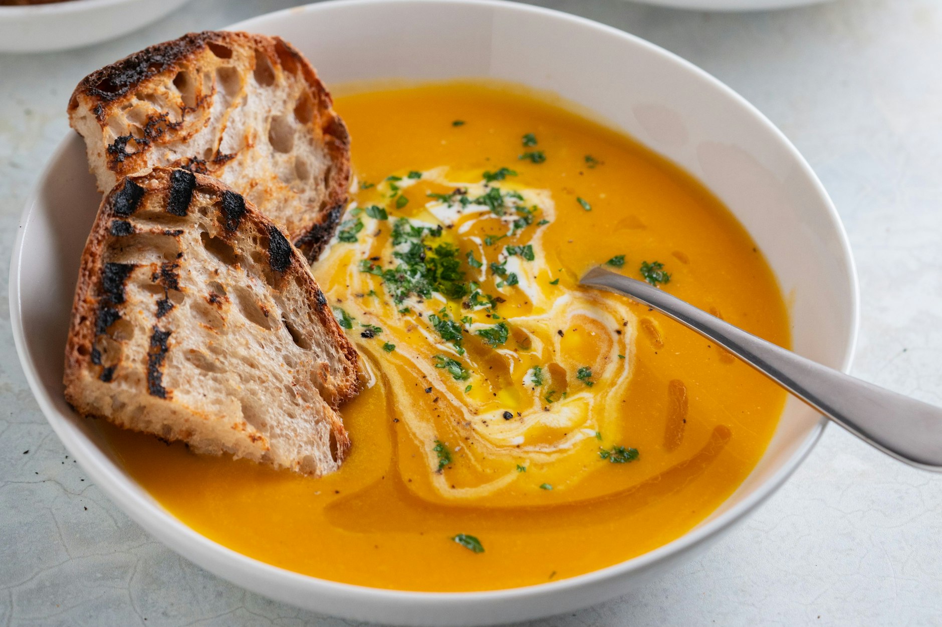 Zu der Karotten-Ingwer-Suppe mit Kokosmilch können Sie geröstetes Brot reichen. Oder Sie garnieren die Suppe mit Croûtons. Wie die gemacht werden, lesen Sie im Rezept.