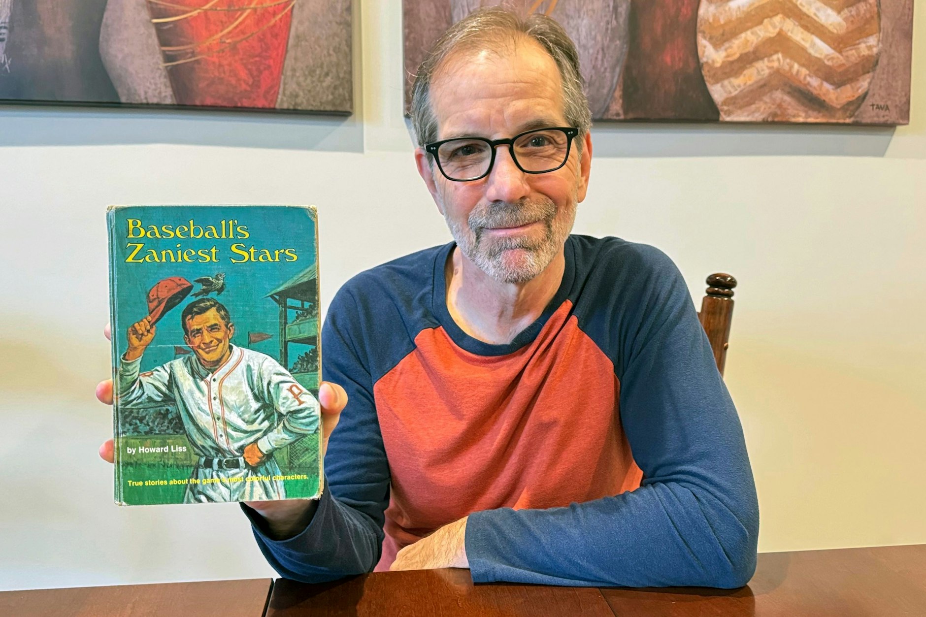 Chuck Hildebrandt zeigt das Buch „Baseball’s Zaniest Stars“, das er 1974 ausgeliehen hatte.