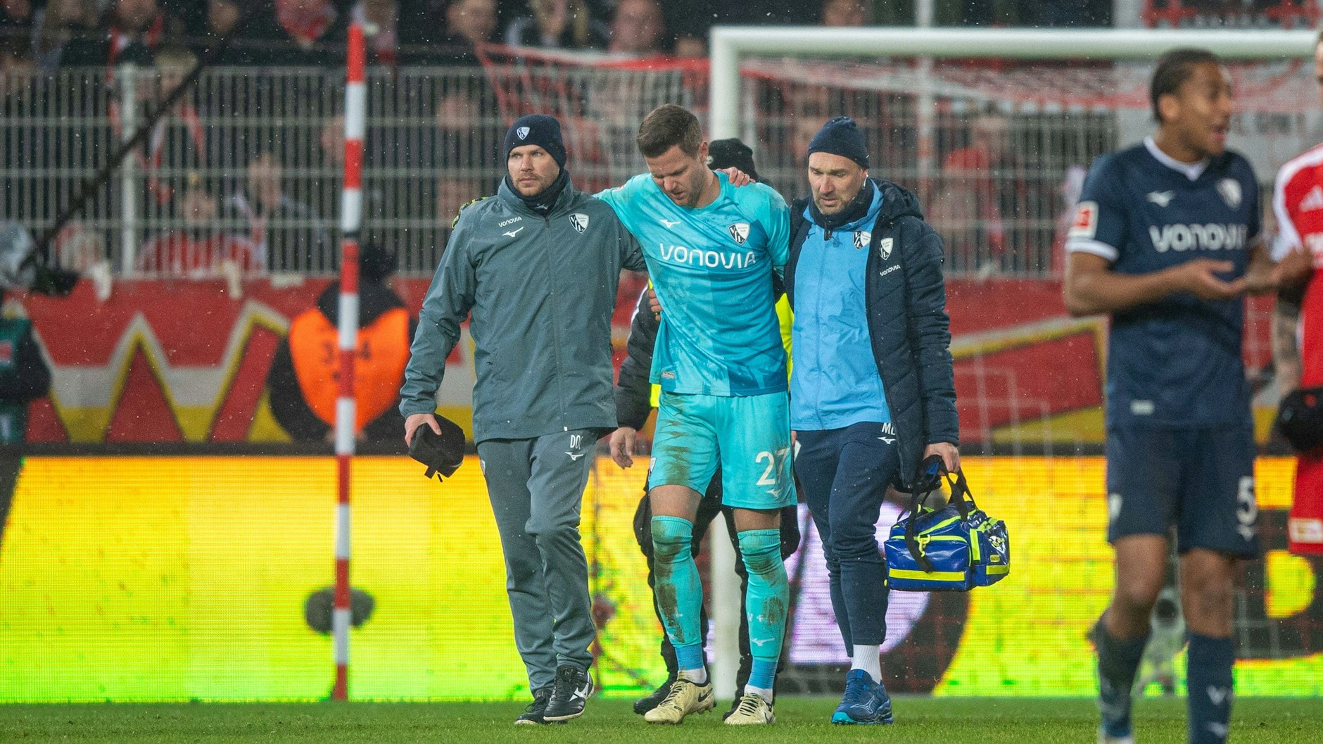 Bochum-Keeper Patrick Drewes (M.) wird von zwei Betreuern vom Platz gebracht.