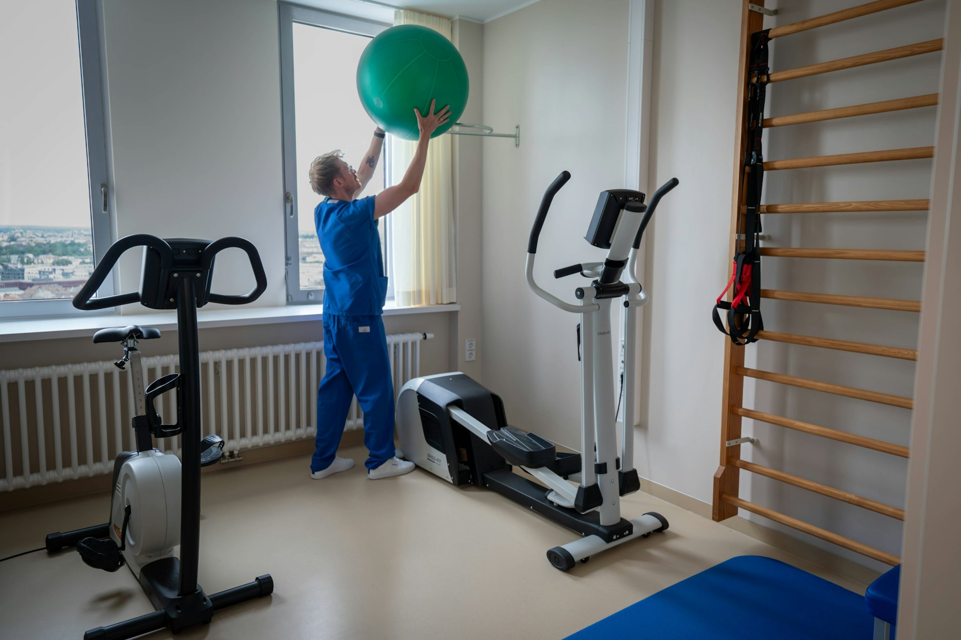 Physiotherapeut mit Gymnastikball in einem Behandlungszimmer der Charité Berlin