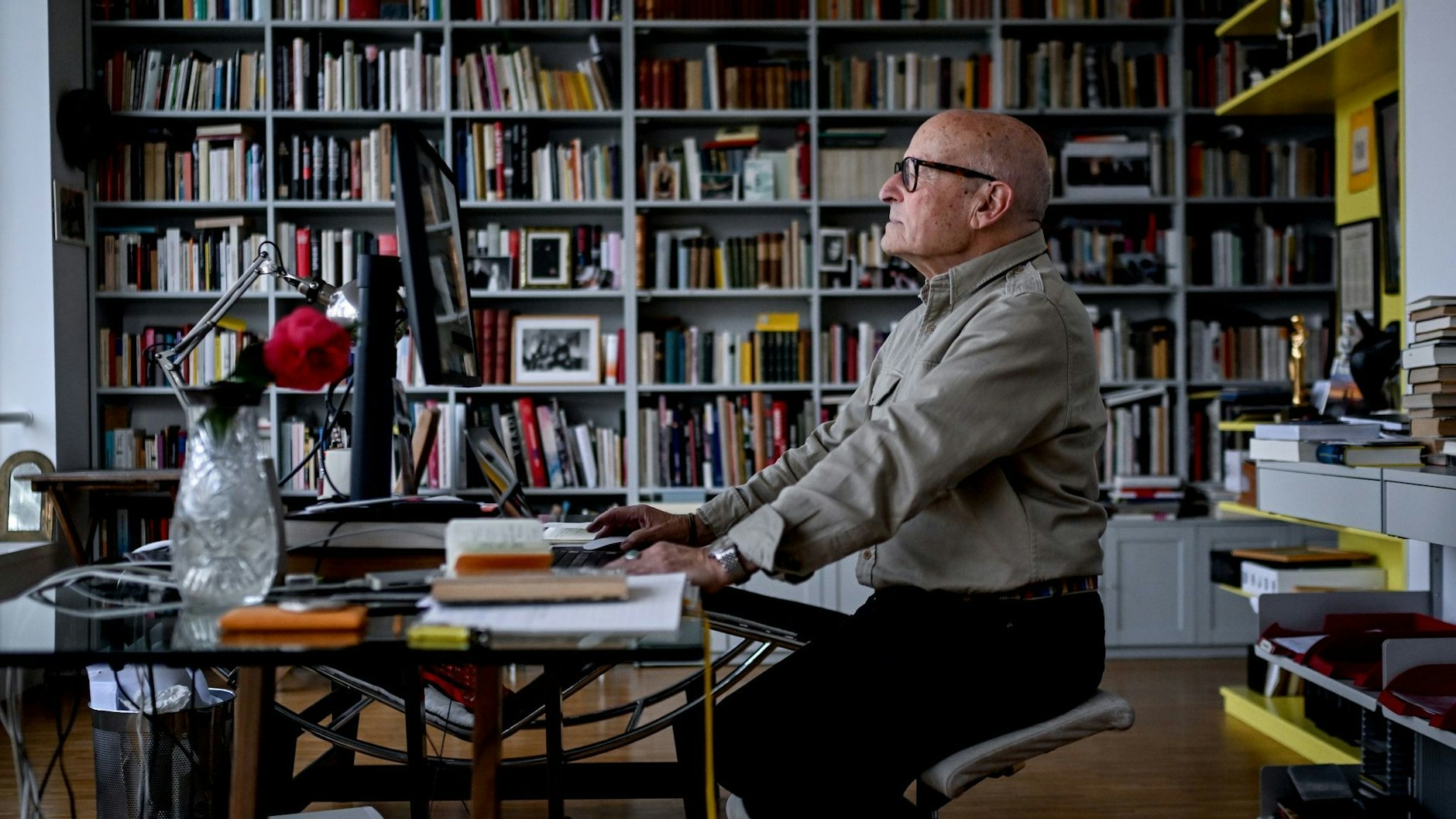 Der Regisseur Volker Schlöndorff sitzt an seinem Schreibtisch in seinem Arbeitszimmer.