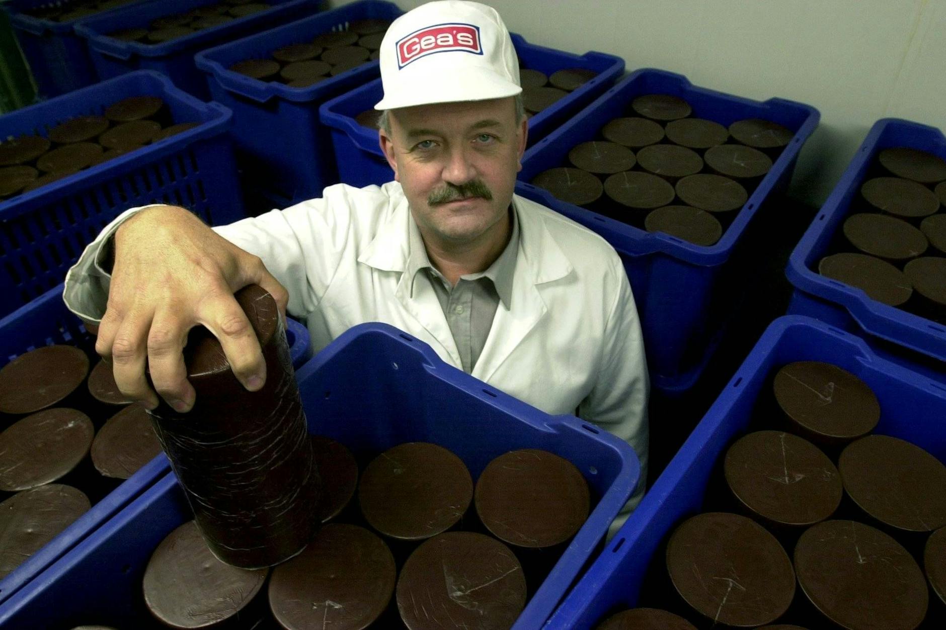 In der Blutpuddingfabrik in Lännersta: Blutpudding liegt in runden Behältern, bereit zur Verpackung. Mitarbeiter Mats Carlsson sortiert die Blutpuddings in blaue Kunststoffschalen.
