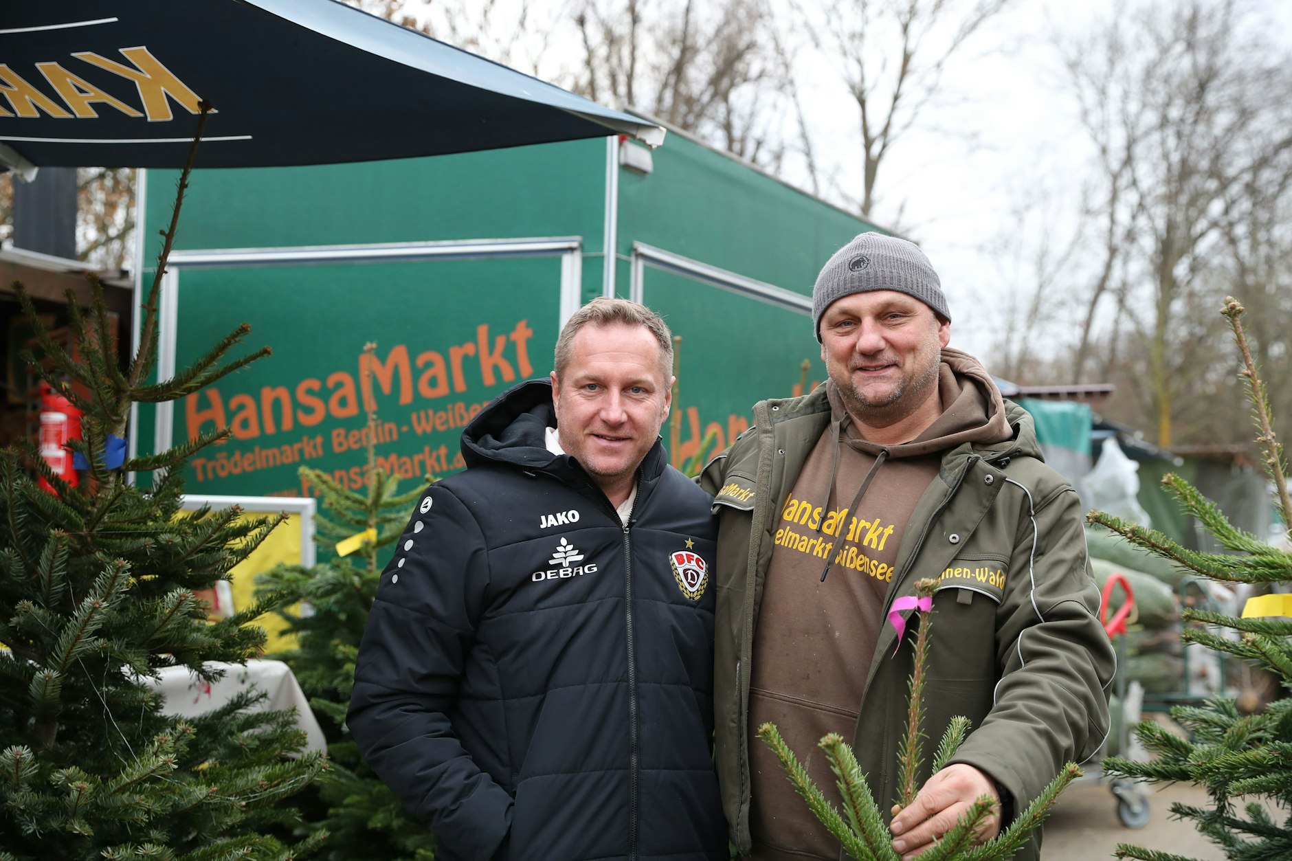 BFC-Trainer Dennis Kutrieb bekommt bei der Tannenbaum-Suche Hilfe von Marktleiter Marlon Siart.