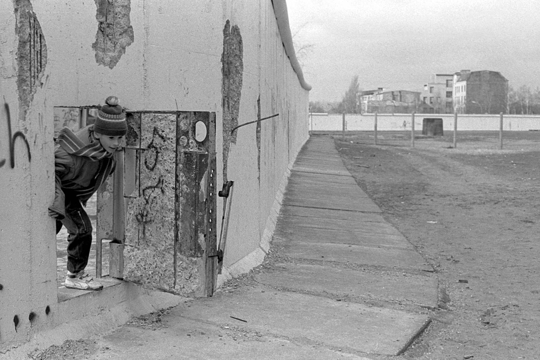 26. Februar 1990: Ein Kind schaut durch eine Tür in der Mauer nahe dem Potsdamer Platz.