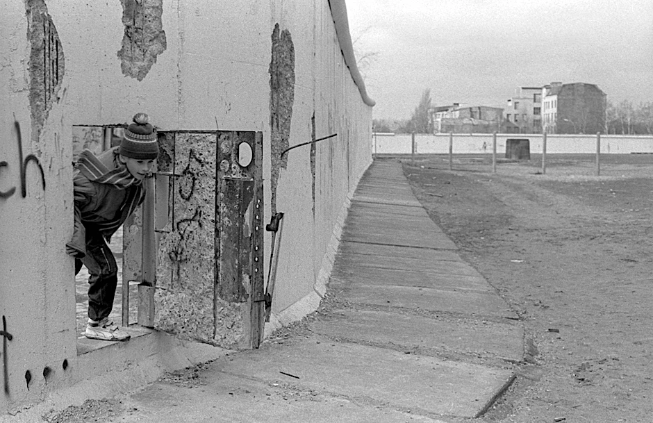 26. Februar 1990: Ein Kind schaut durch eine Tür in der Mauer nahe dem Potsdamer Platz.
