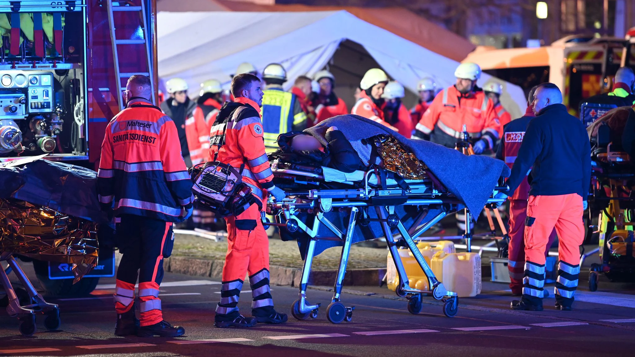Ein Opfer des Anschlags auf den Magdeburger Weihnachtsmarkt wird von Rettern abtransportiert.