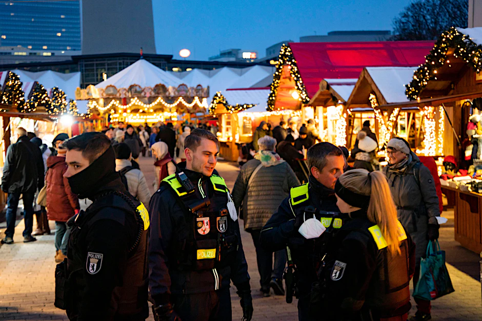 Berliner Polizisten patrouillieren auf einem Weihnachtsmarkt.