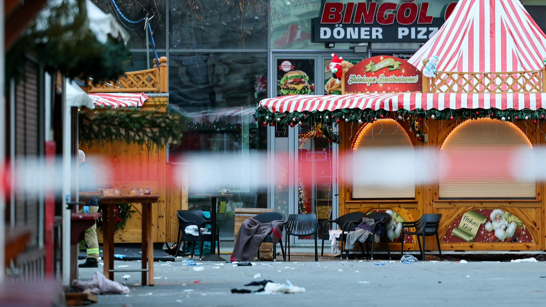 Decken und Stühle von Verletzten stehen hinter einer Absperrung am Magdeburger Weihnachtsmarkt. 
