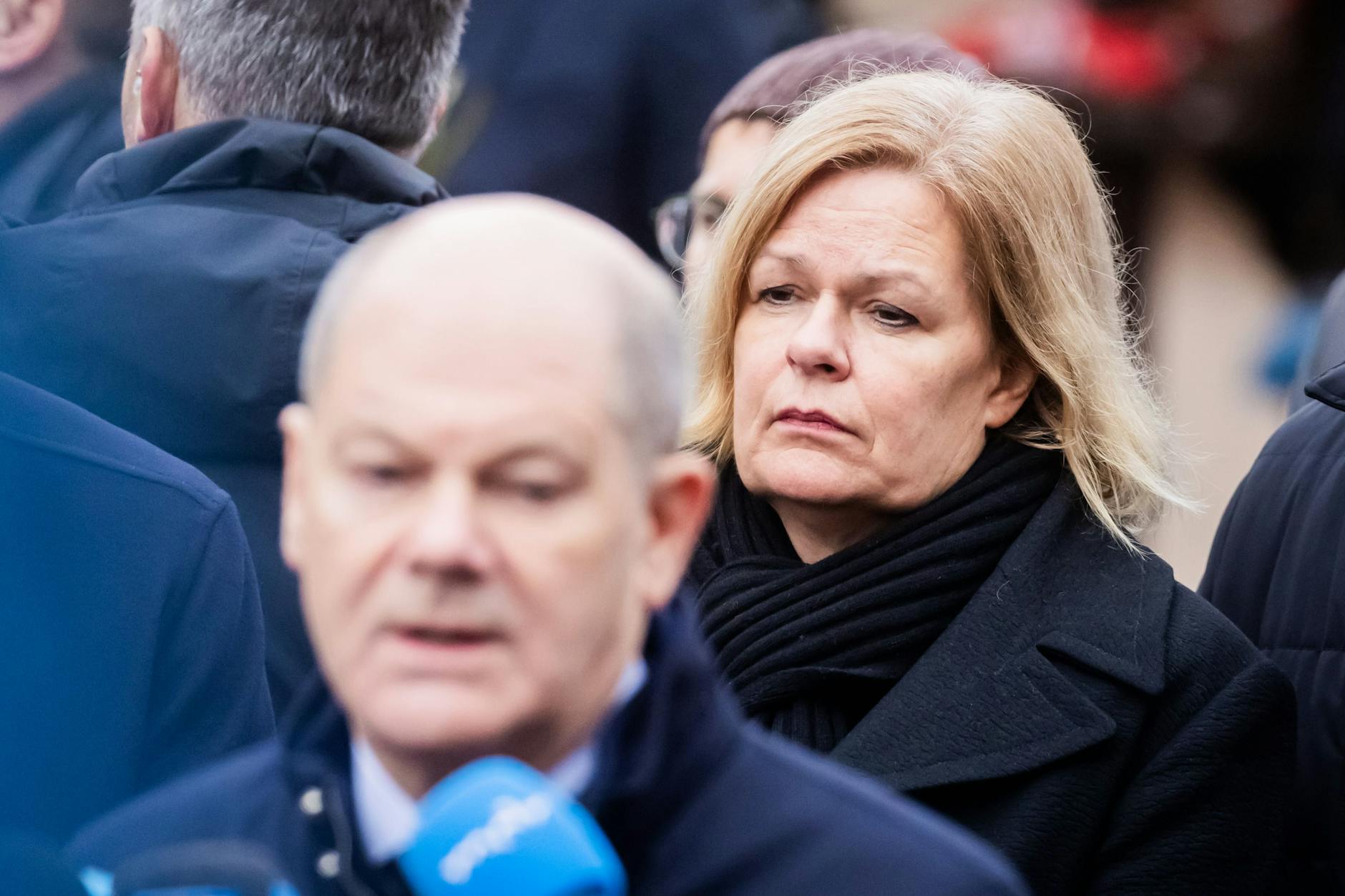 21.12.2024, Sachsen-Anhalt, Magdeburg: Nancy Faeser (SPD), Bundesministerin für Inneres und Heimat, steht neben Bundeskanzler Olaf Scholz (SPD) auf dem Weihnachtsmarkt in Magdeburg, als dieser ein Statement gibt. Auf dem Weihnachtsmarkt in Magdeburg ist ein Autofahrer in eine Menschengruppe gefahren.