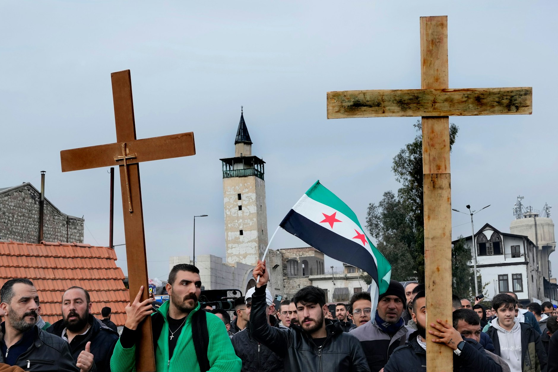 Damaskus am Heiligabend: Syrische Christen tragen Kreuze bei einer Demonstration, nachdem Unbekannte in Sukailabija den Weihnachtsbaum in Brand gesetzt hatten.
