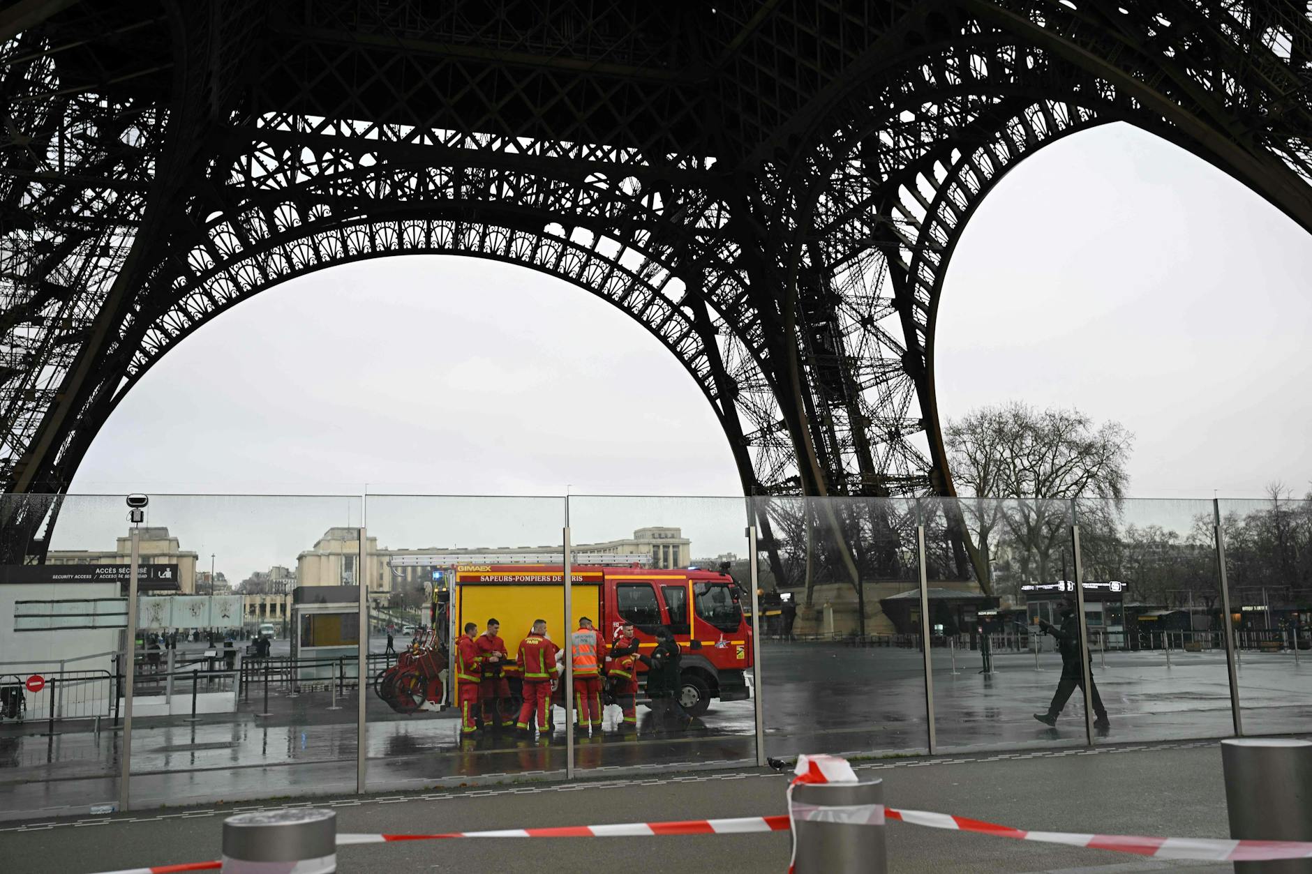 Französische Feuerwehrleute stehen um ihr Fahrzeug am Fuß des Eiffelturms, wo am 24. Dezember 2024 in Paris ein Feuer gemeldet wurde.