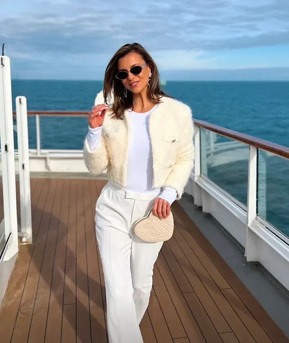 Laura Wontorra ganz in Weiß mit Felljäckchen und Sonnenbrille auf ihrer Aussteigerreise.
