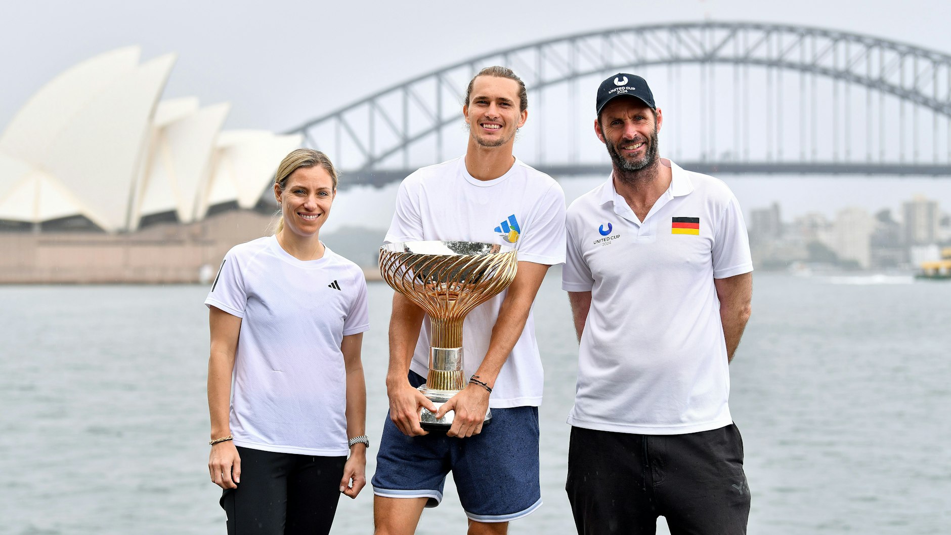 Angelique Kerber, Alexander Zverev und Trainer Torben Beltz posieren im Januar 2024 mit dem Pokal für den Sieg beim United Cup.