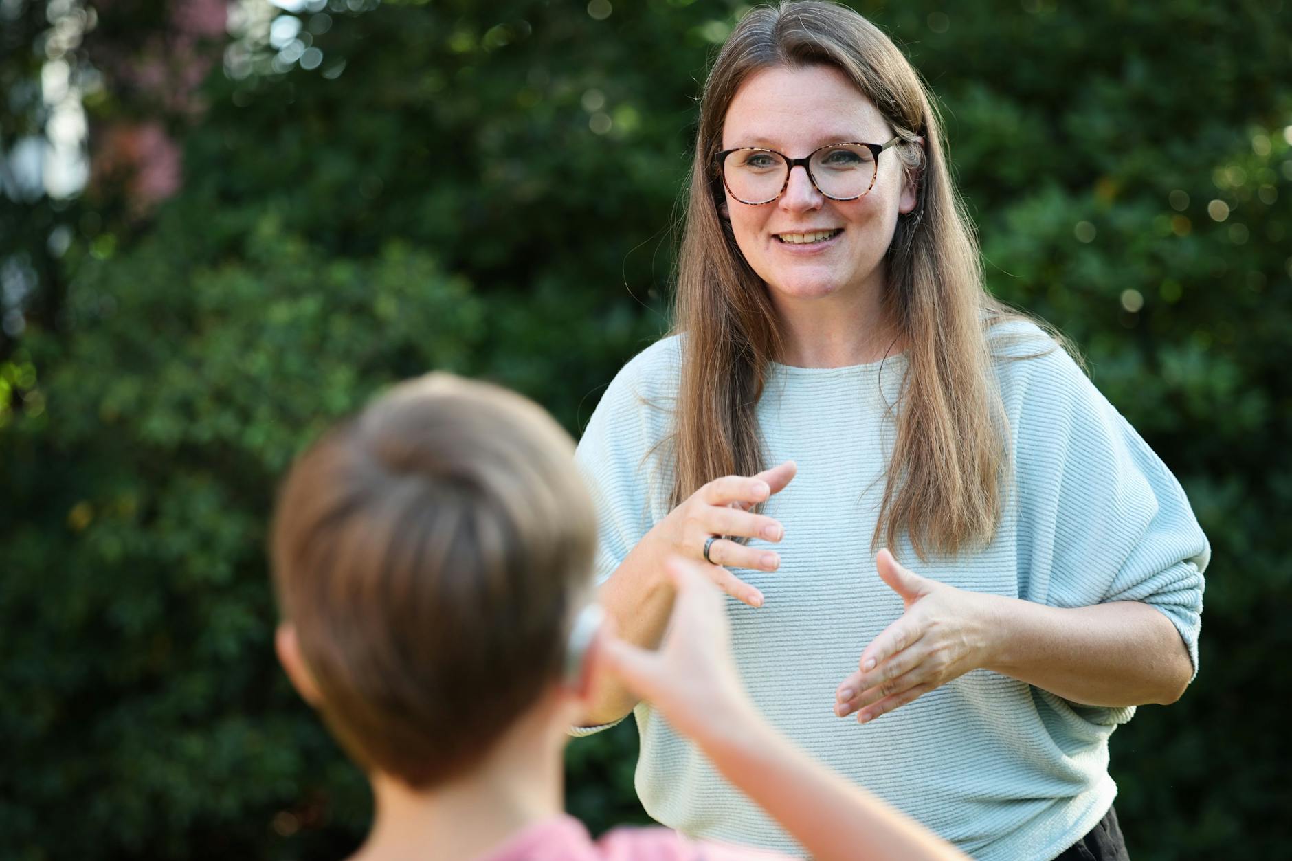 Romy Ballhausen, Vizepräsidentin des Bundeselternverbands gehörloser Kinder, unterhält sich in Gebärdensprache mit ihrem Sohn.