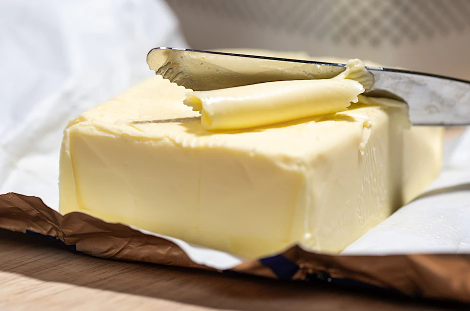 Ein Stück Butter liegt auf einem Tisch. (Symbolbild)