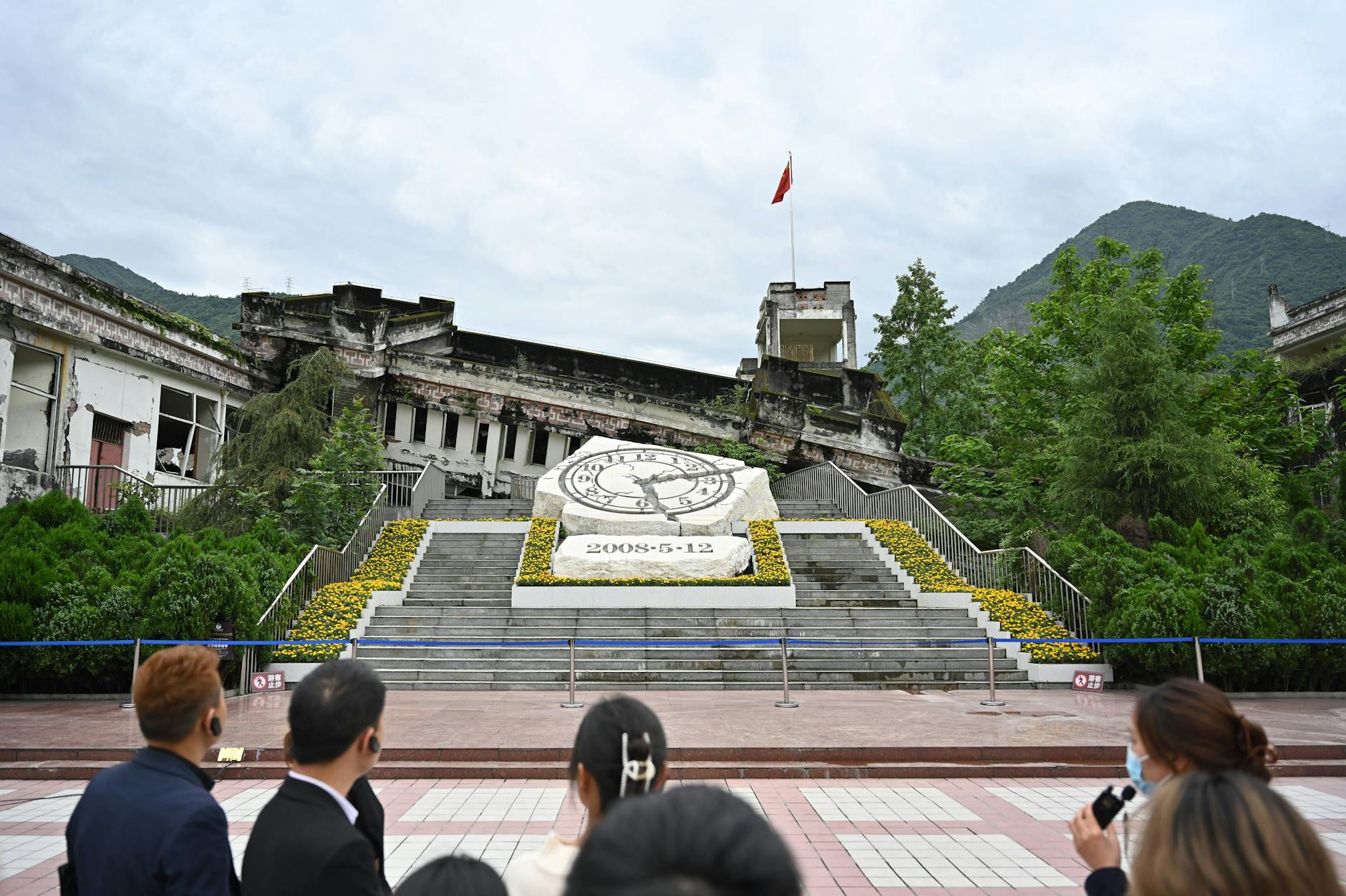 Menschen besichtigen die Ruinen der Xuankou-Mittelschule, die heute eine Gedenkstätte für das Erdbeben in Wenchuan 2008 sind.
