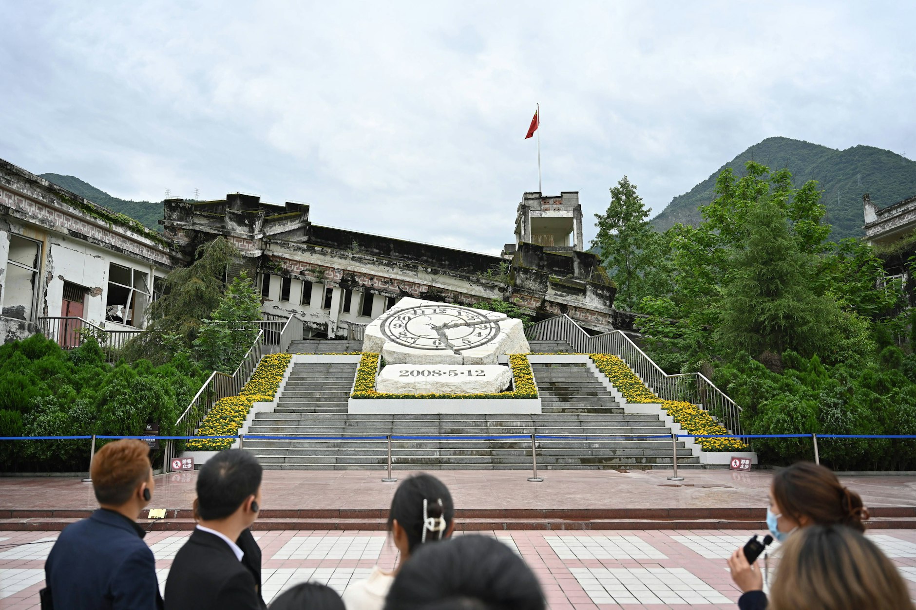 Menschen besichtigen die Ruinen der Xuankou-Mittelschule, die heute eine Gedenkstätte für das Erdbeben in Wenchuan 2008 sind.