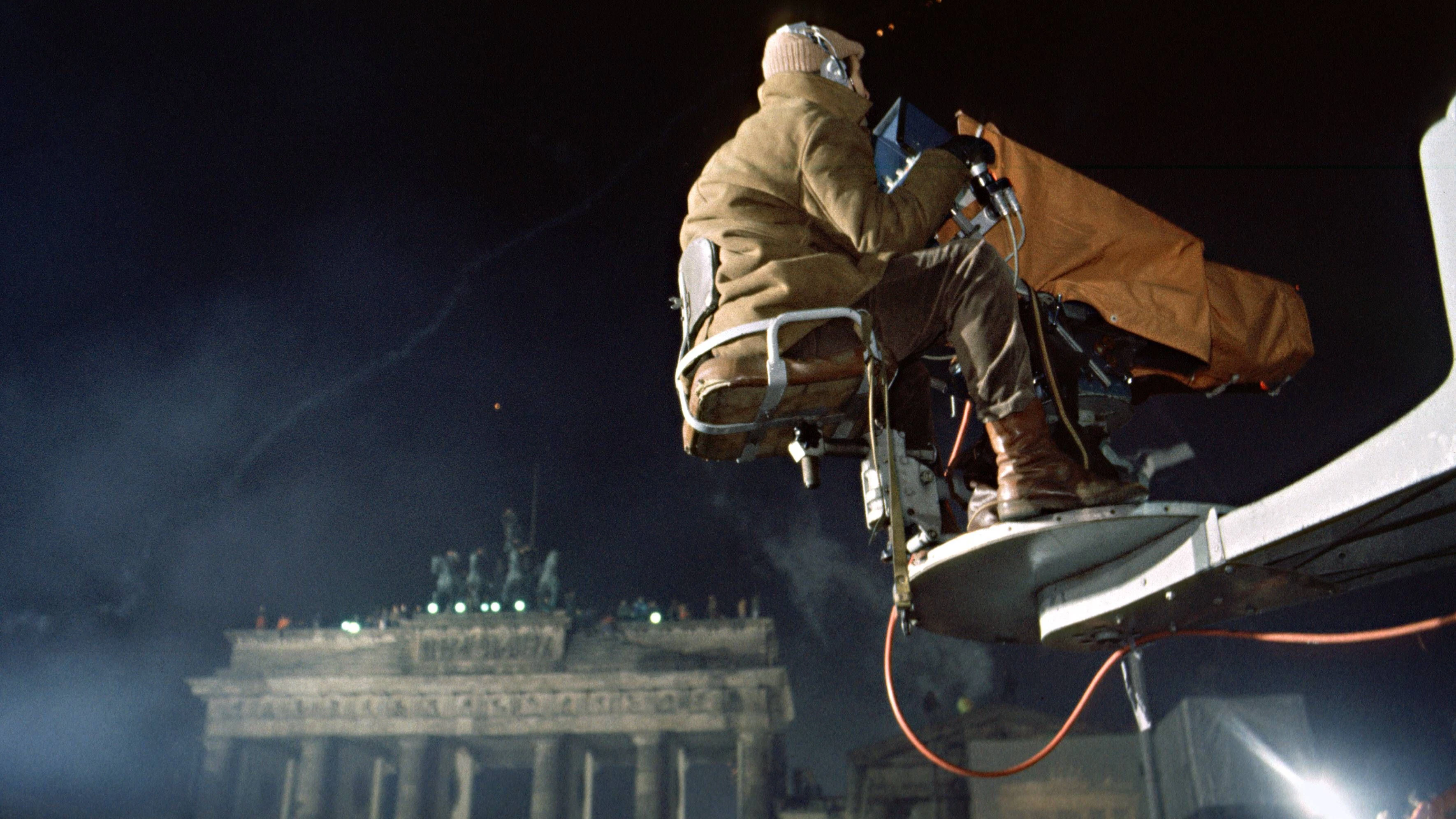 Silvester 1989 am Brandenburger Tor: Ein Kameramann des DDR-Fernsehens, dahinter ist das Gerüst mit der Videoleinwand zu sehen, die später zusammenbrach.