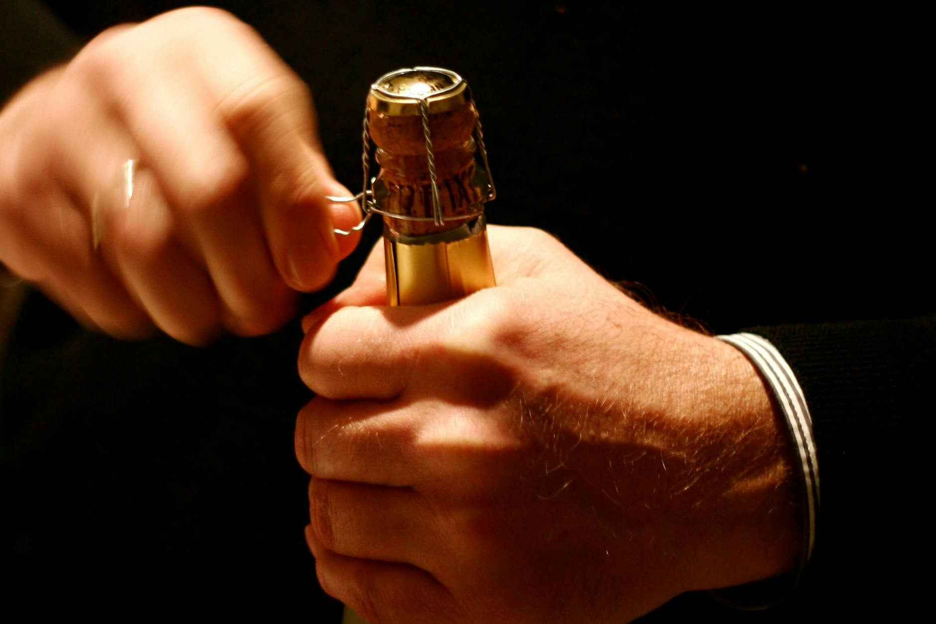 Fast richtig: Beim Öffnen des Drahts (Muselet) an der Sektflasche sollte der Daumen der anderen Hand den Korken sichern.