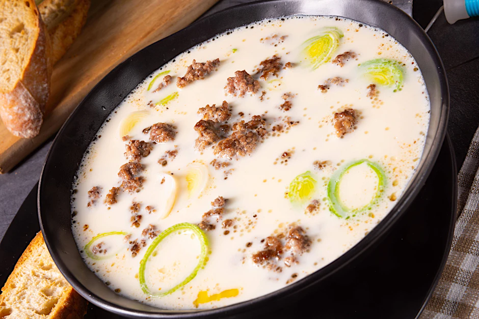 Ein dampfender Teller voll cremiger Lauch-Käse-Suppe – perfekt serviert mit knusprigem Brot.