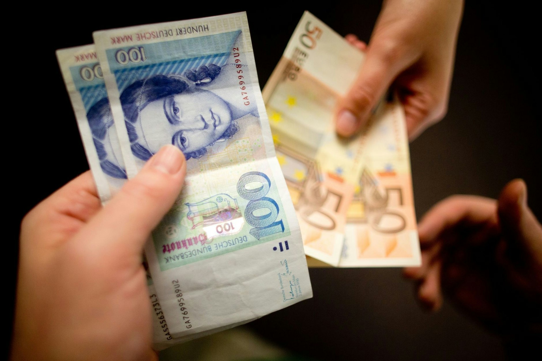 D-Mark-Scheine werden gegen Euro-Scheine getauscht.