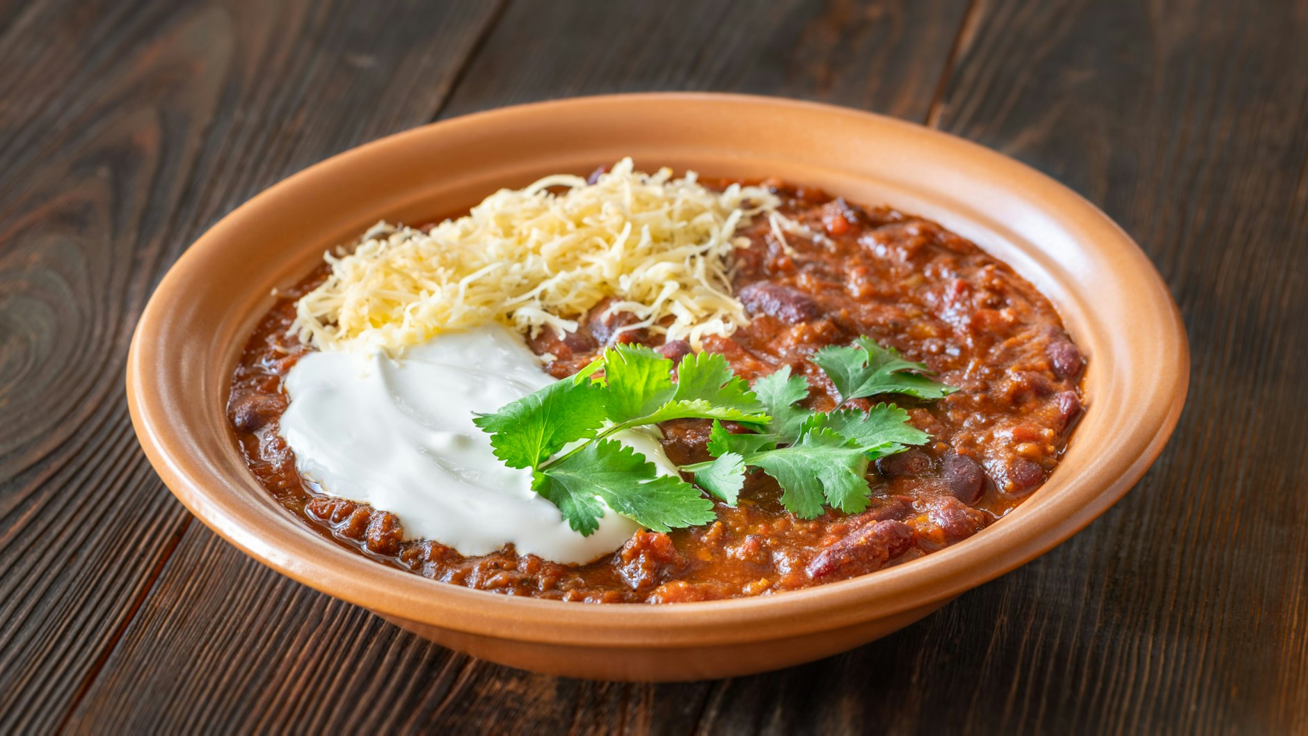 Mit Schmand und Reibekäse können Sie das Chili con Carne noch verfeinern.