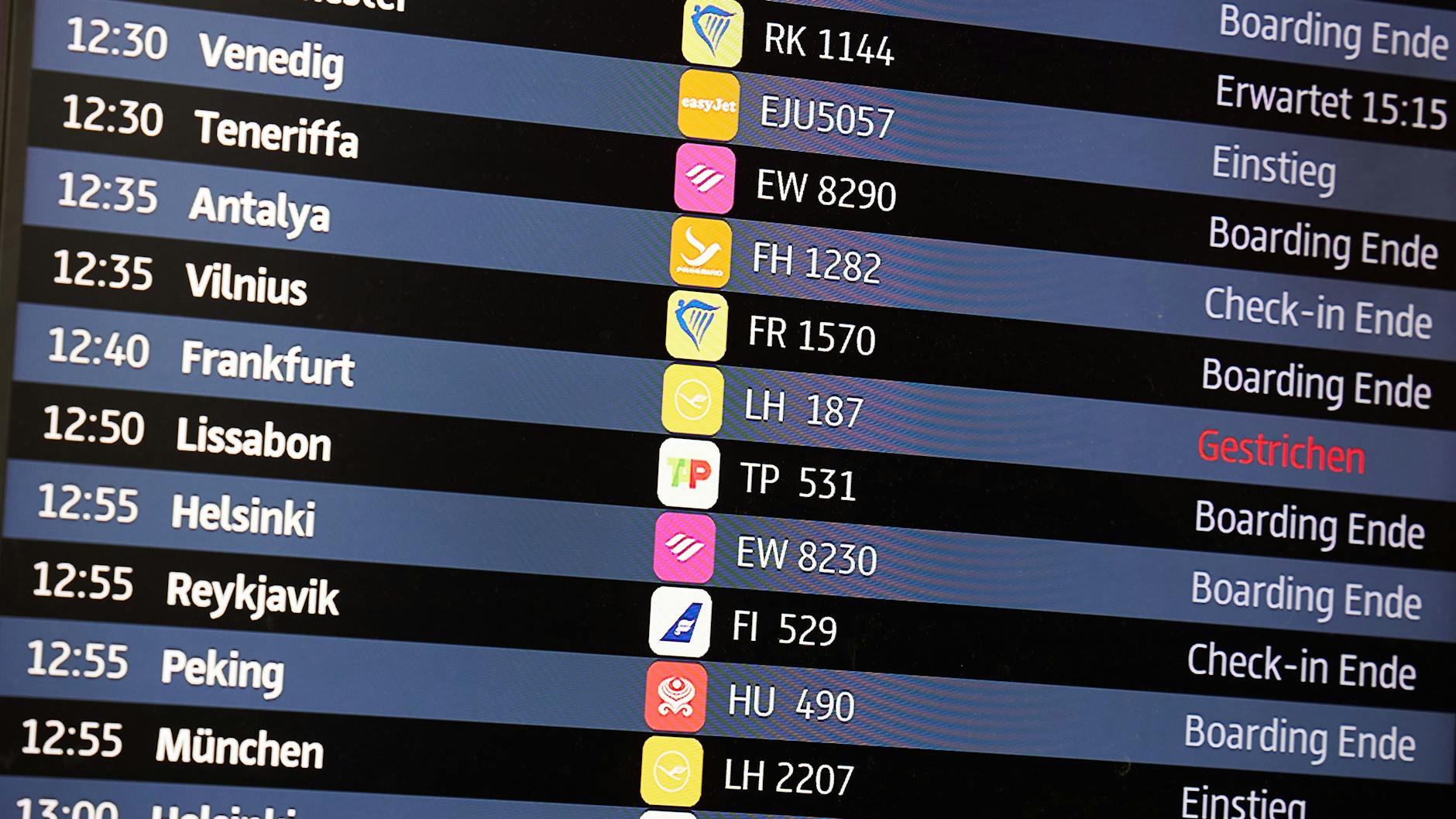 Am Flughafen BER wird auf einem Bildschirm angezeigt, dass ein Lufthansa-Flug nach Frankfurt gestrichen wurde. Schnee und Eisregen sorgen an deutschen Flughäfen dafür, dass zahlreiche Flieger nicht starten können.
