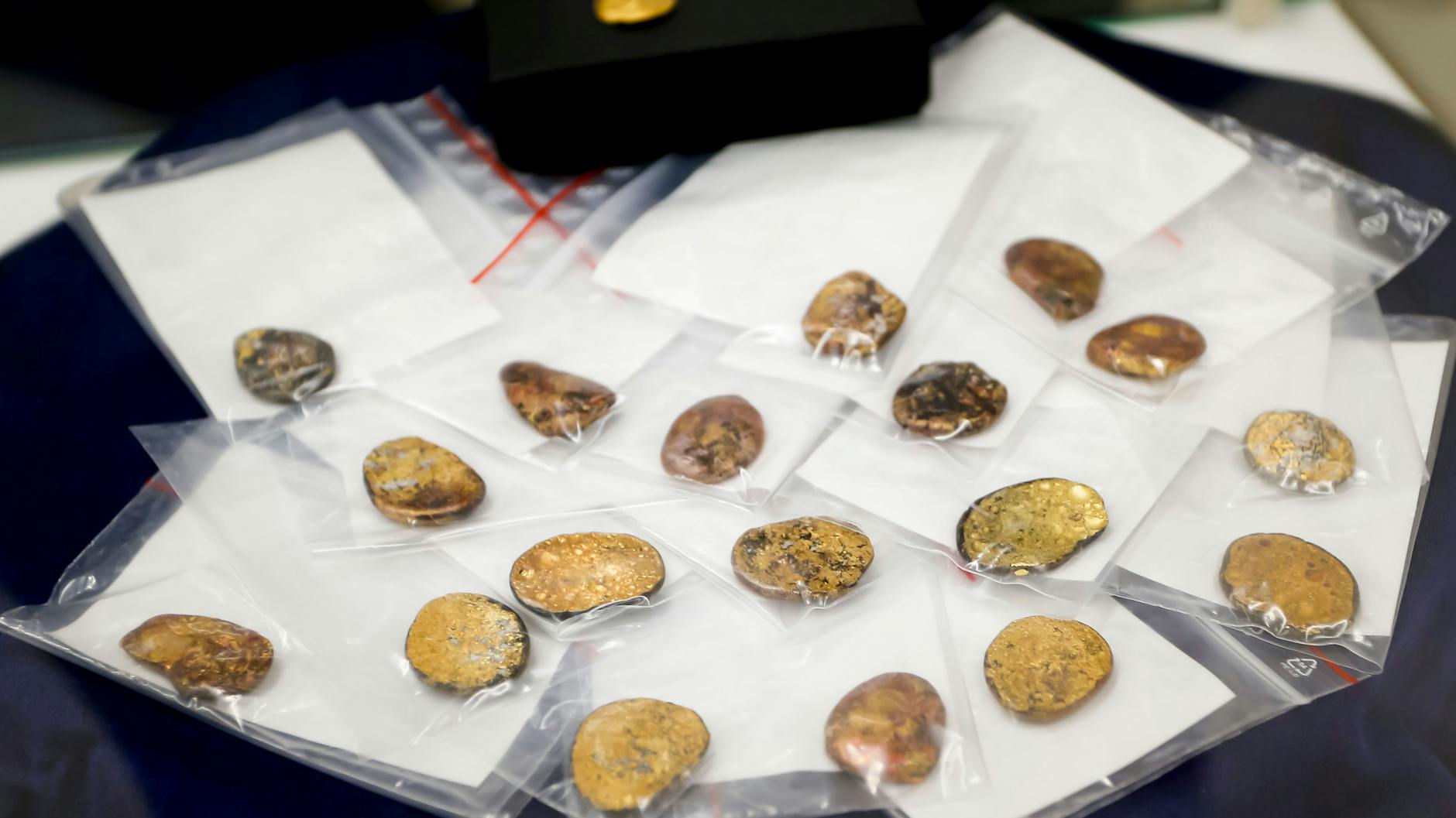 20.07.2023: Sichergestellte Münzklumpen werden während einer Pressekonferenz des bayerischen Landeskriminalamts zu den Festnahmen im Fall des Manchinger Goldschatz-Diebstahls präsentiert. (Archivbild)