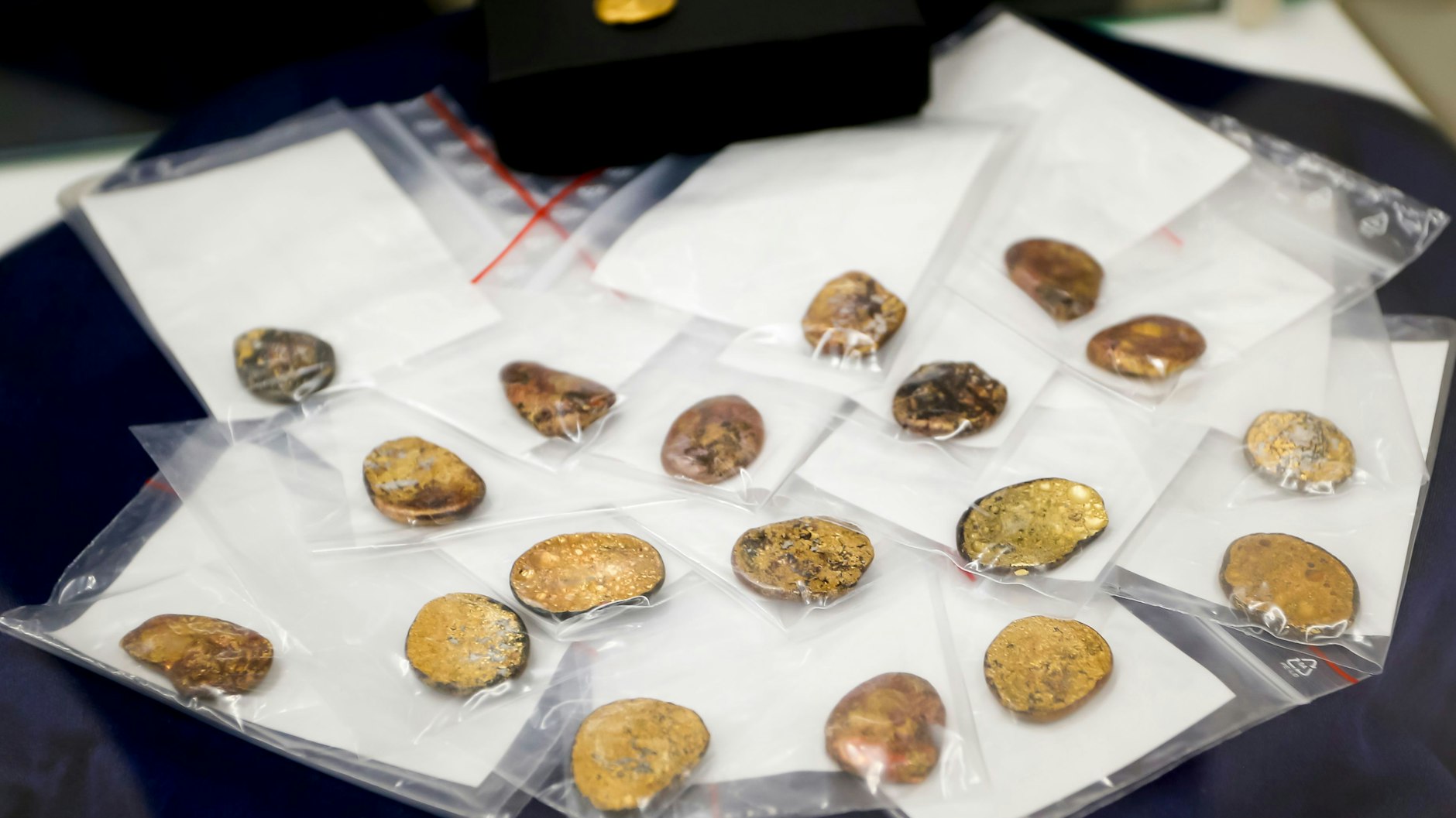 20.07.2023: Sichergestellte Münzklumpen werden während einer Pressekonferenz des bayerischen Landeskriminalamts zu den Festnahmen im Fall des Manchinger Goldschatz-Diebstahls präsentiert. (Archivbild)