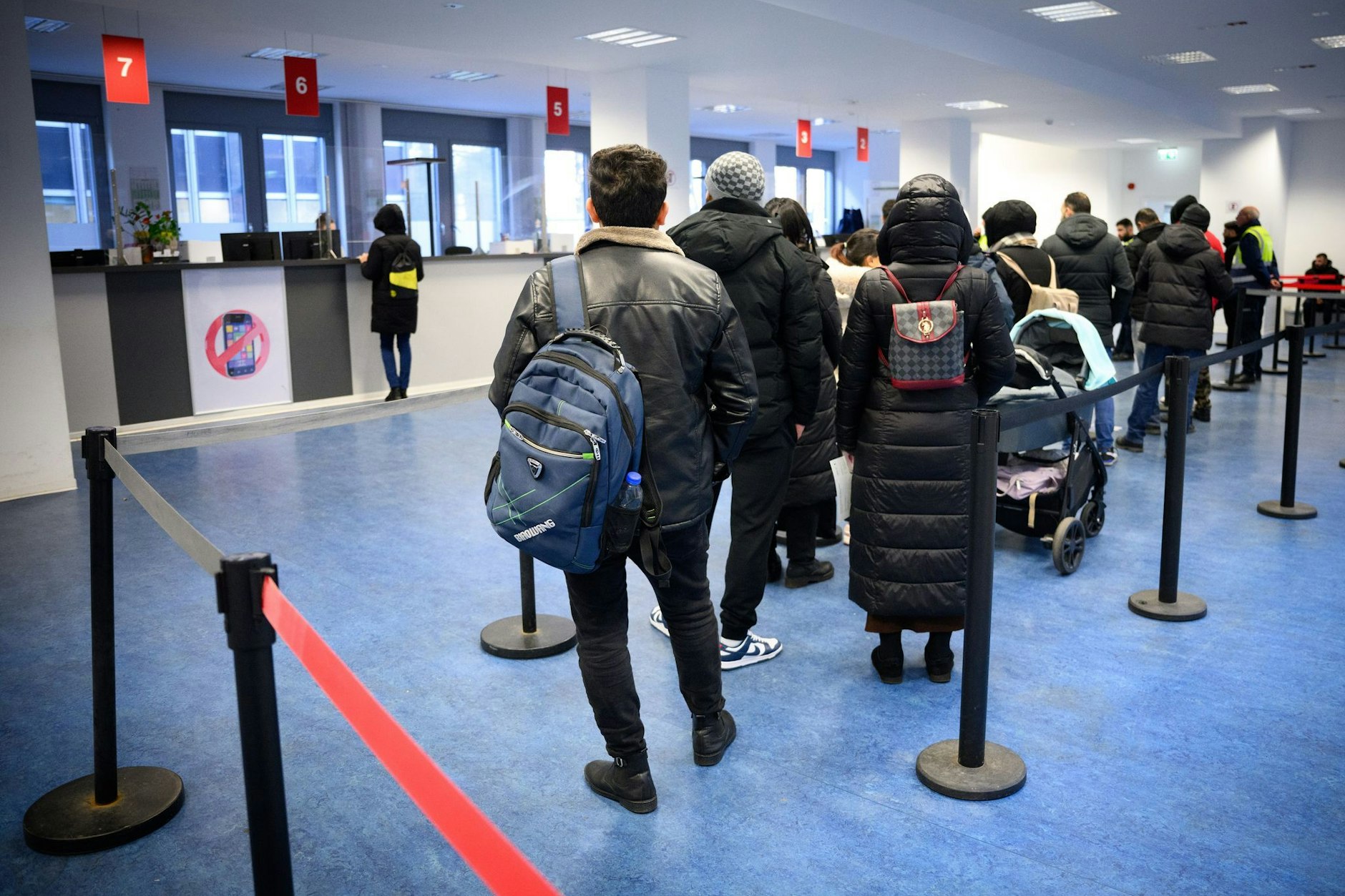Besucher warten vor Informationsschaltern im Landesamt für Flüchtlingsangelegenheiten (LAF) in Berlin-Charlottenburg.