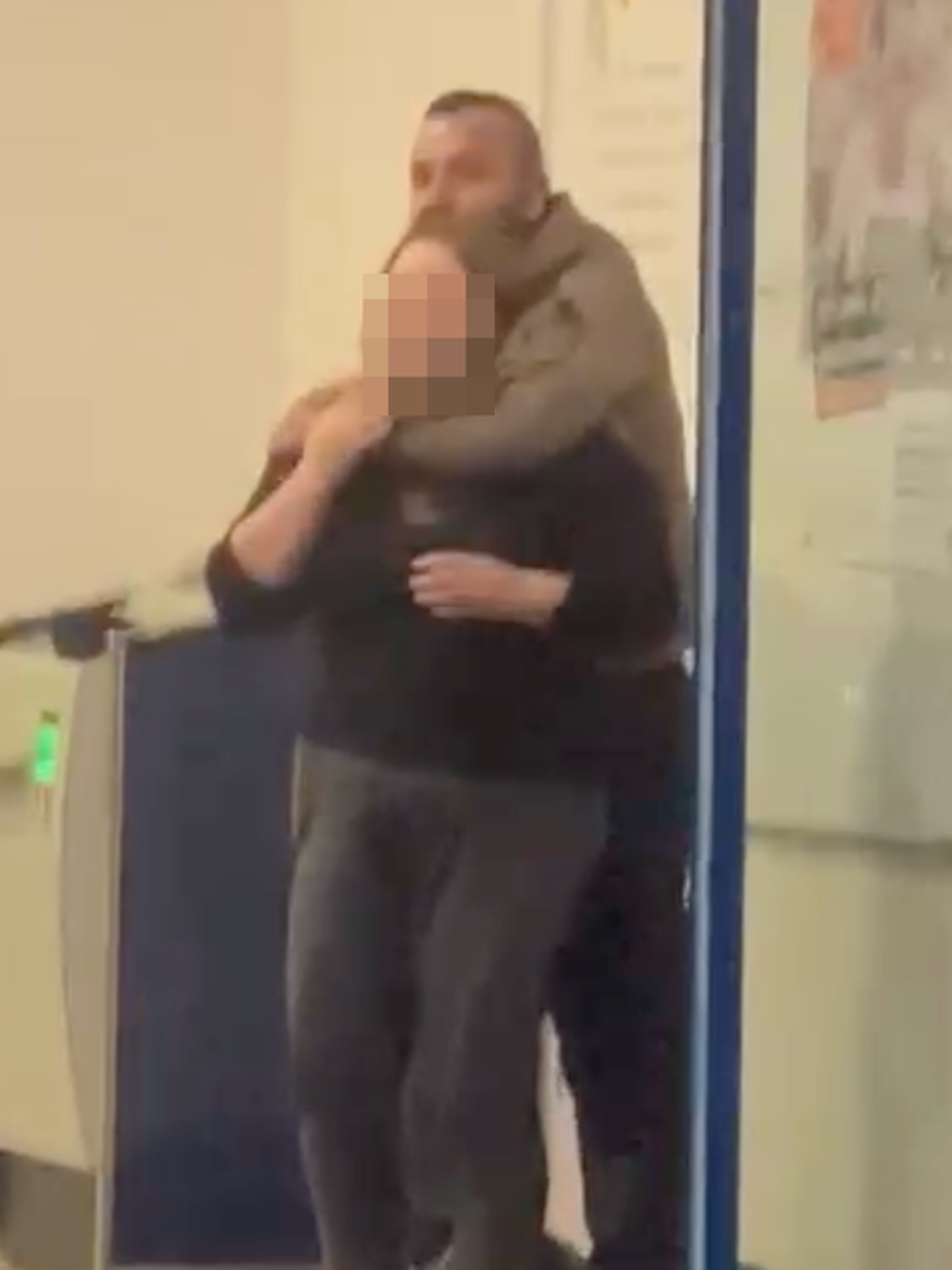 Der Täter im Foyer der Bank - er hält der Geisel ein Messer an den Hals.  
