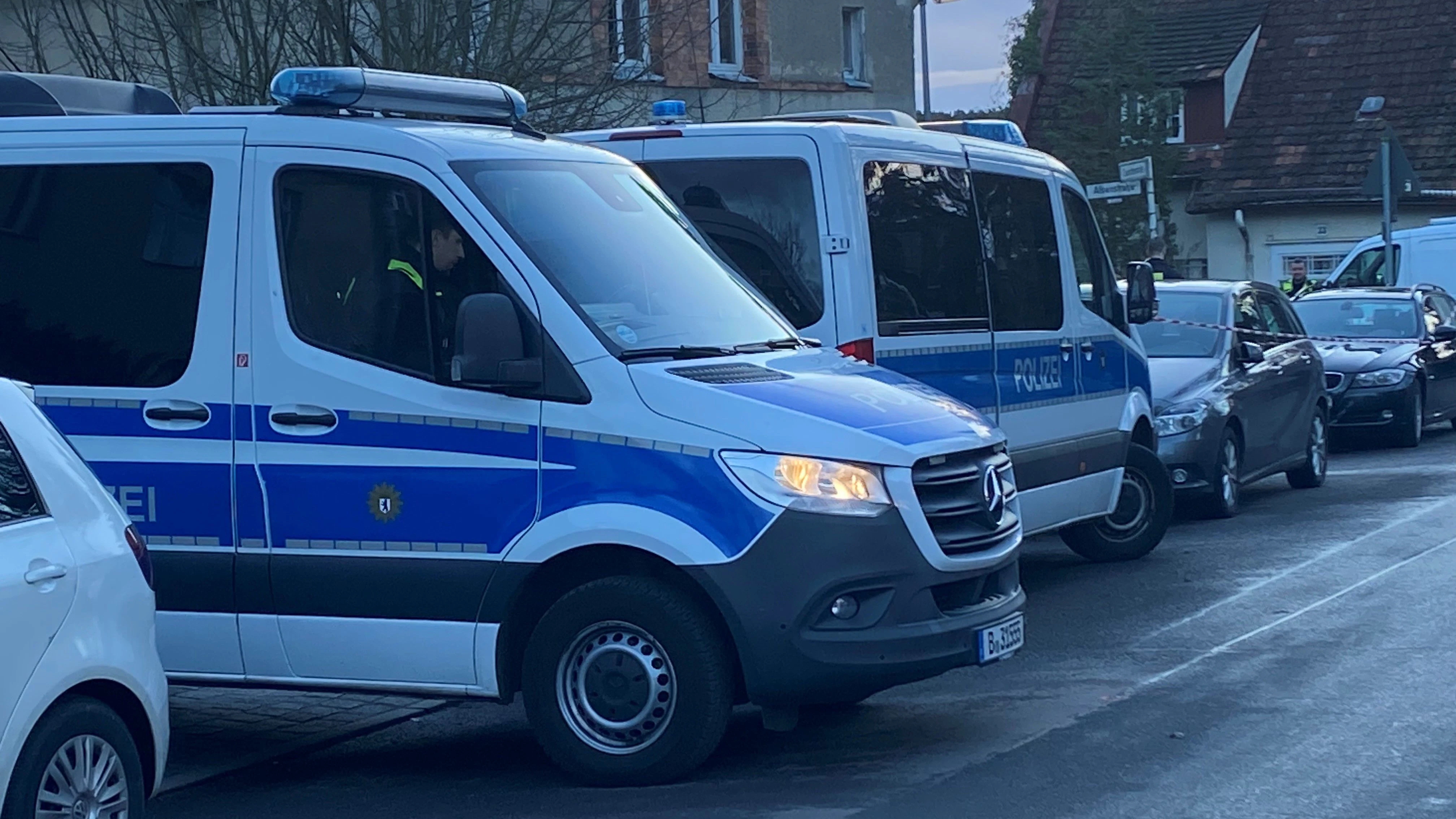 Polizeiwagen stehen vor dem Grundstück in Berlin-Wannsee nahe einer Schule. Dort wird nach einer Leiche gesucht.