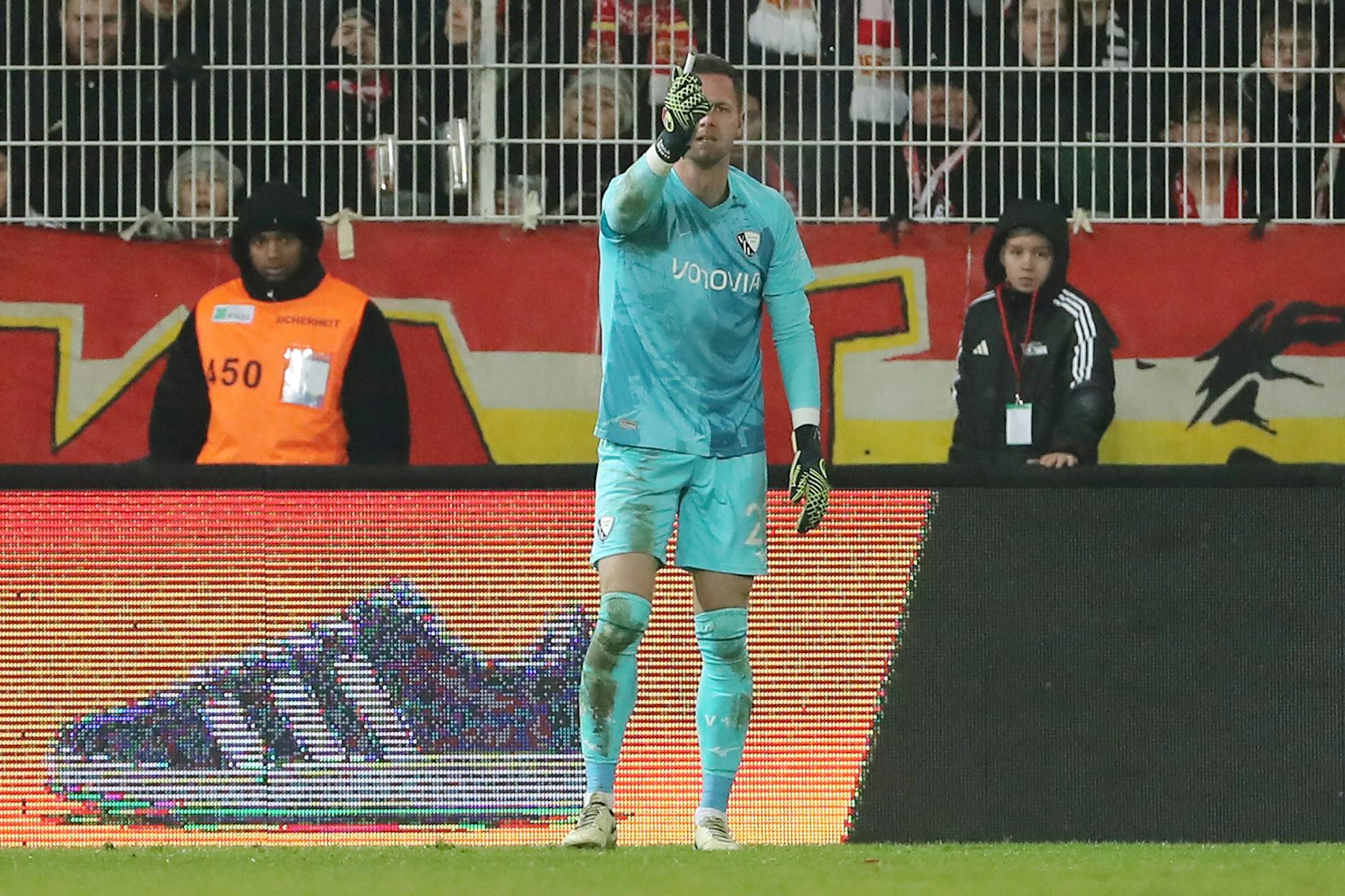 Bochums Torwart Patrick Drewes zeigt dem Schiri das Feuerzeug, das ihn leicht getroffen hatte. Danach sackte der Keeper zu Boden.