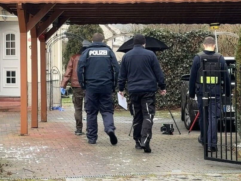 Einsatzkräfte der Polizei betreten ein Grundstück, nachdem ein Polizist bei einem Einsatz in Berlin-Köpenick auf einen Mann geschossen hat. 