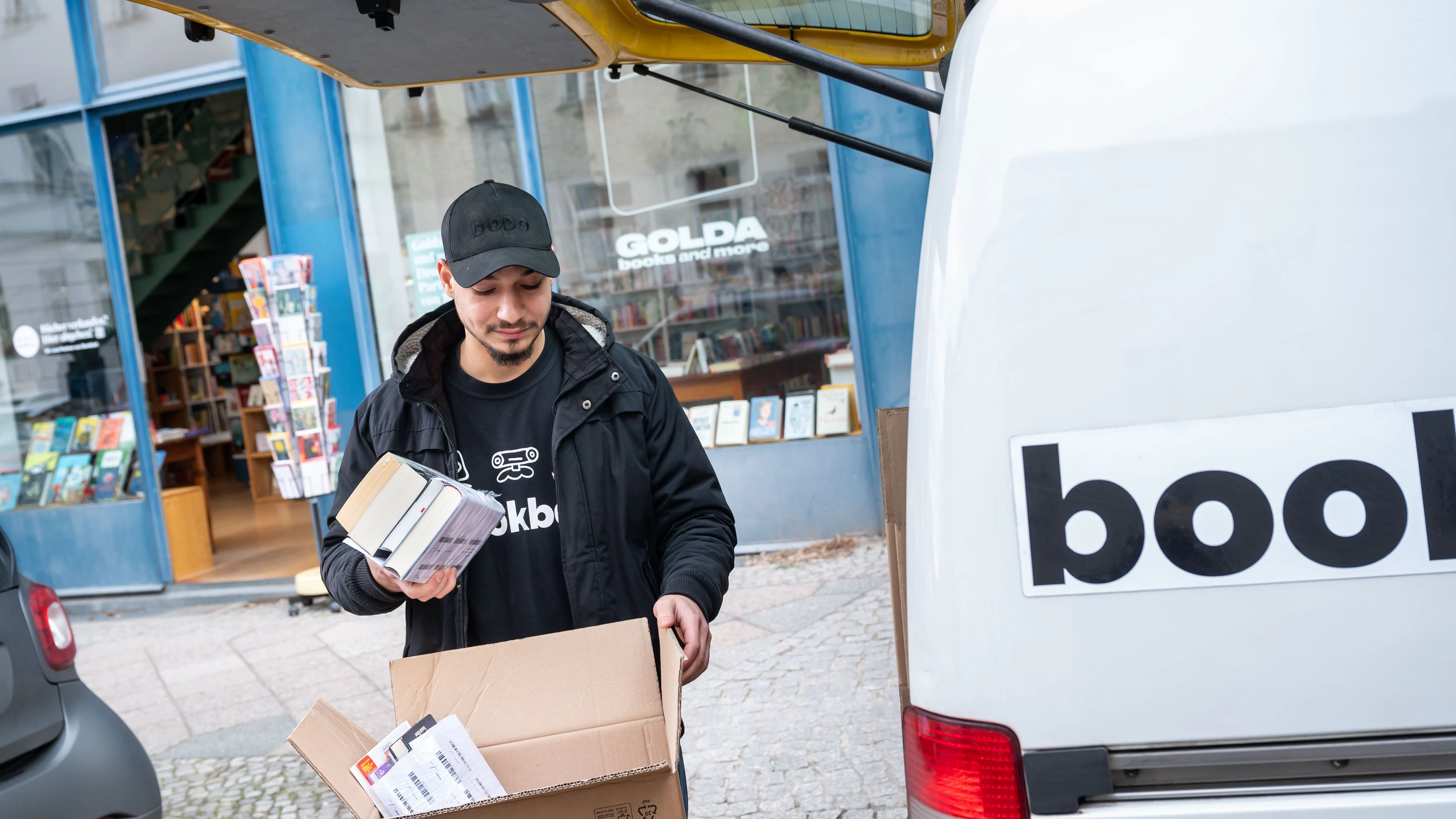 In der Buchhandlug Golda in Mitte können gebrauchte Bücher abgegeben werden, die dann über das Re-Commerce Unternehmen Bookbot abgeholt und wiederverkauft werden. Hier lädt der Kurier Rami einige Kisten mit gesammelten Büchern ein.