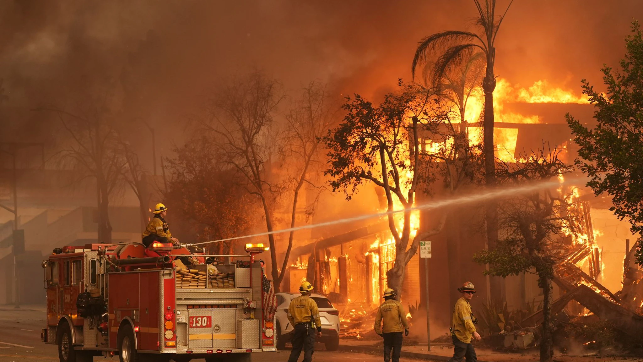 Feuerwehrleute löschen ein brennendes Gebäude in der Lake Avenue in der Innenstadt von Altadena.